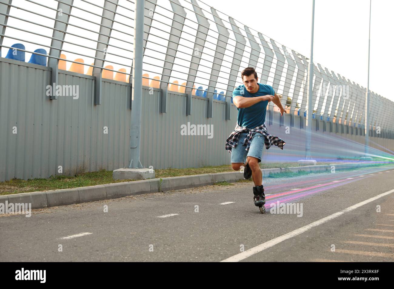 Junger Mann Rollschuhlaufen im Freien. Lichtspuren zeigen seine Geschwindigkeit Stockfoto