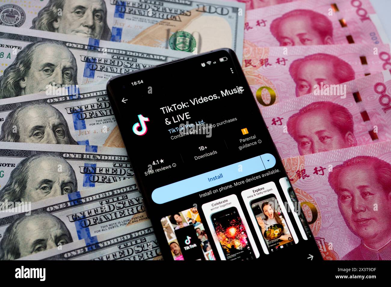 TikTok App auf dem Bildschirm des Smartphones, die auf US-Dollar und chinesische Yuan-Banknoten platziert ist. Stafford, Vereinigtes Königreich, 28. April 2024 Stockfoto