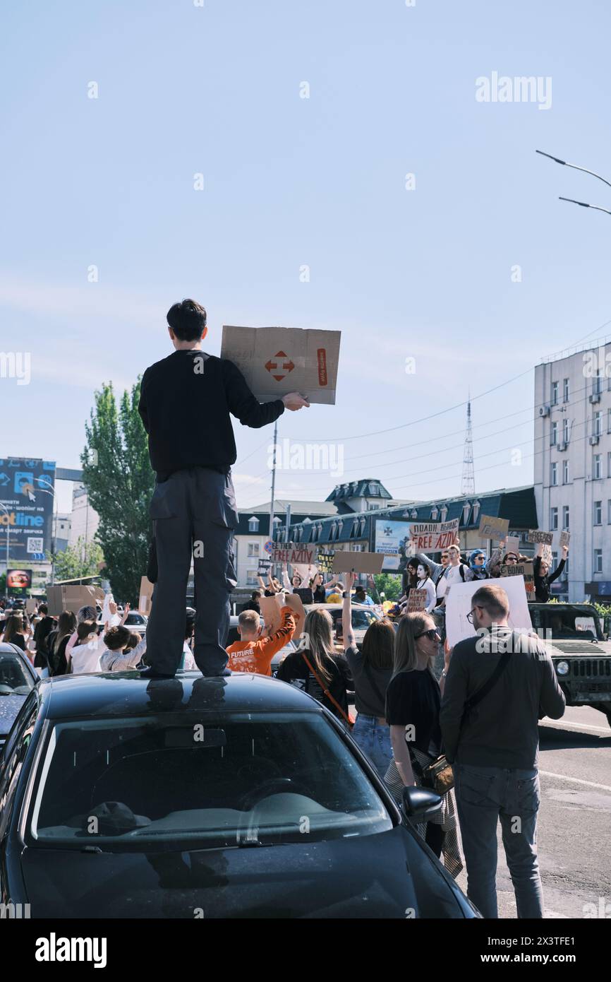 Kiew, Ukraine - 28. April 2024. Ukrainische Demonstranten schwenken stolz Flaggen und Banner der Asow-Brigade mit der Aufschrift Free Asow, die Einheit und Aktivismus veranschaulichen Stockfoto