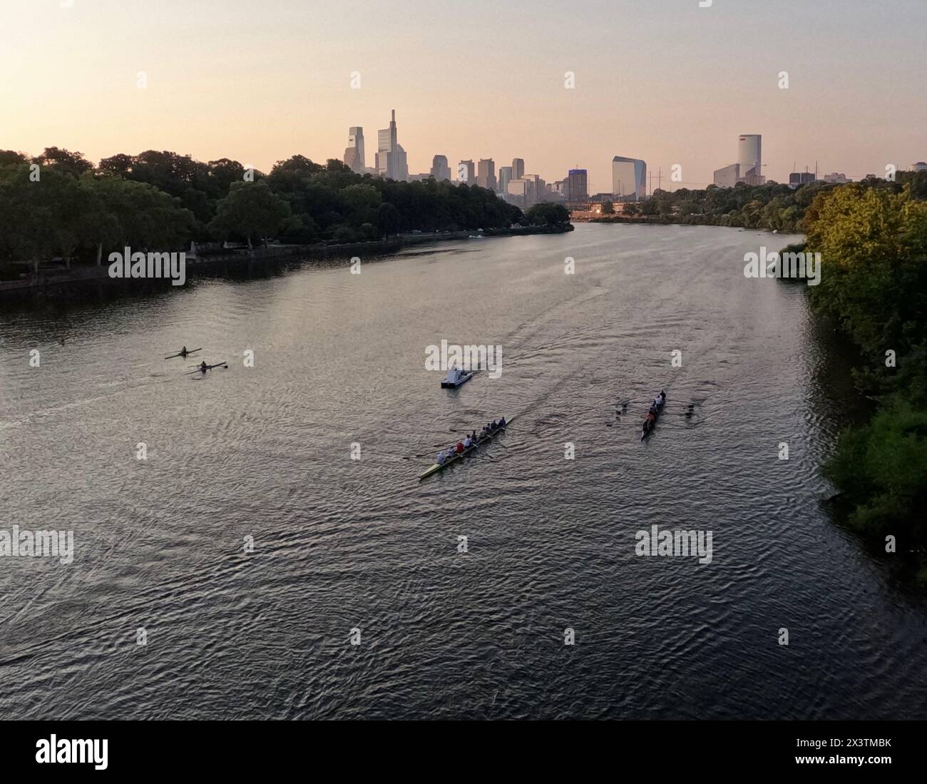 Ruderer fahren nach Norden entlang des Schuylkill River mit der Skyline von Philadelphia dahinter. Stockfoto