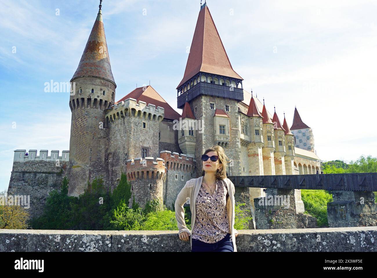 Eine weibliche Touristin steht vor der Burg Corvin - der Hauptattraktion der rumänischen Stadt Hunedoara Stockfoto