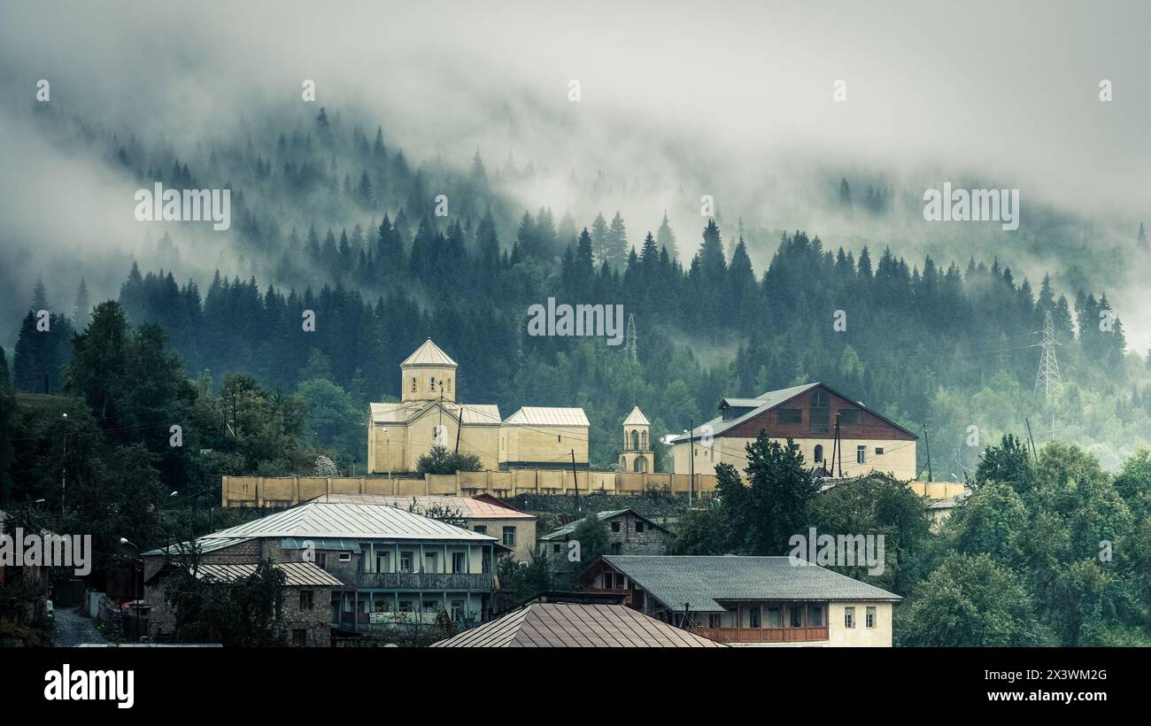 Blick auf die Kirche im Nebel, Mestia, Georgia. St. Nikolaus Kirche in Mestia Stockfoto