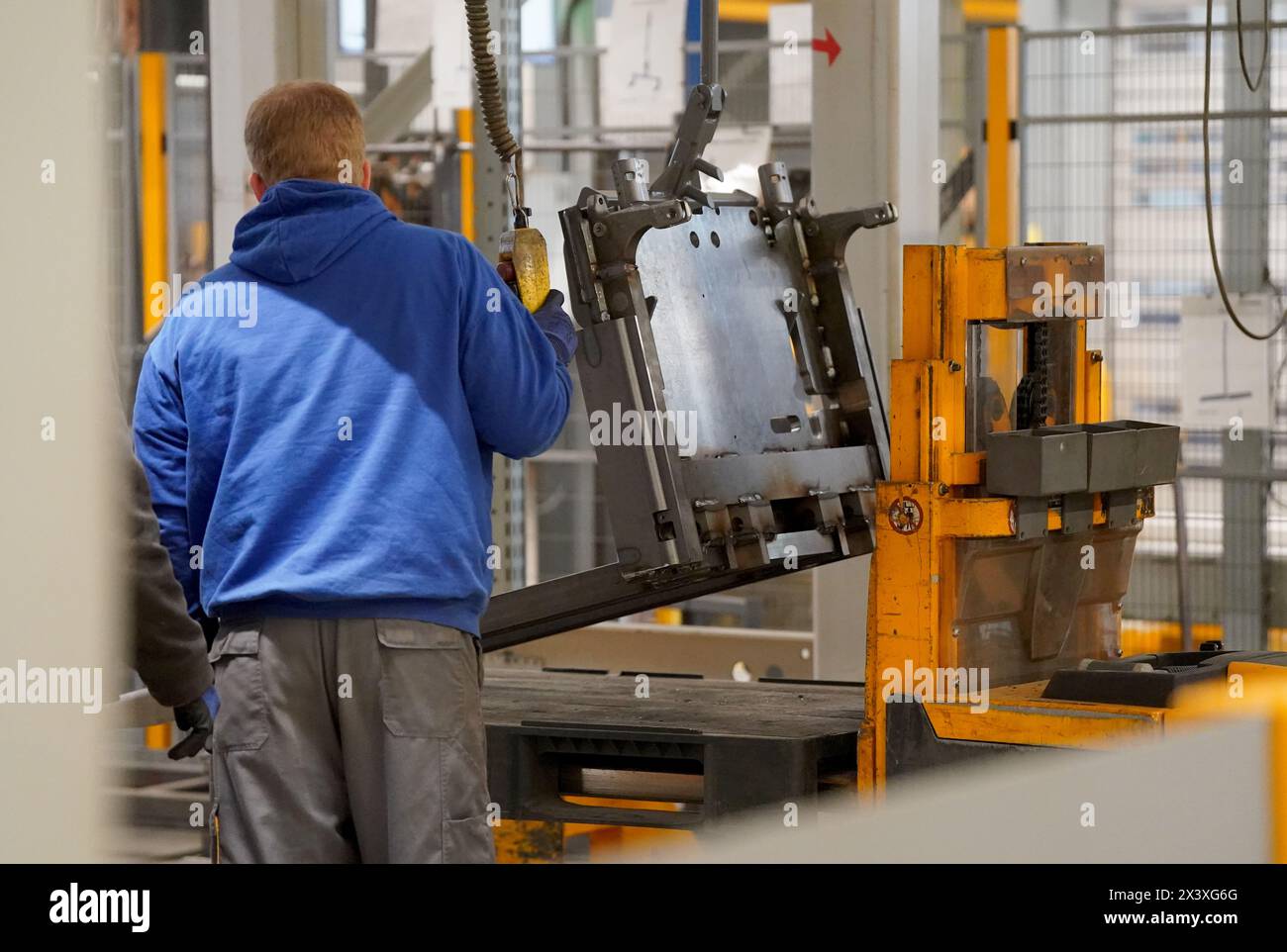 24. April 2024, Schleswig-Holstein, Norderstedt: Mitarbeiter bereiten die Masten für die Pulverbeschichtung im Werk Jungheinrich AG vor. Jungheinrich ist ein Hersteller von Gabelstaplern und Palettenhubwagen. Foto: Marcus Brandt/dpa Stockfoto