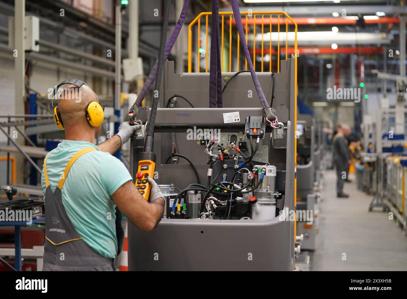 Norderstedt, Deutschland. April 2024. Ein Mitarbeiter arbeitet an der Montagelinie für Flurförderzeuge im Werk Jungheinrich AG. Jungheinrich ist ein Hersteller von Gabelstaplern und Palettenhubwagen. Quelle: Marcus Brandt/dpa/Alamy Live News Stockfoto