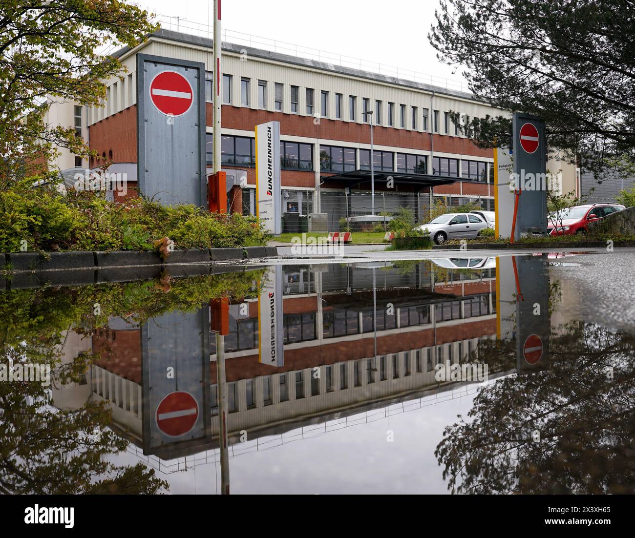 Norderstedt, Deutschland. April 2024. Ein Fabrikgebäude der Jungheinrich AG spiegelt sich in einer Pfütze wider. Jungheinrich ist ein Hersteller von Gabelstaplern und Palettenhubwagen. Quelle: Marcus Brandt/dpa/Alamy Live News Stockfoto