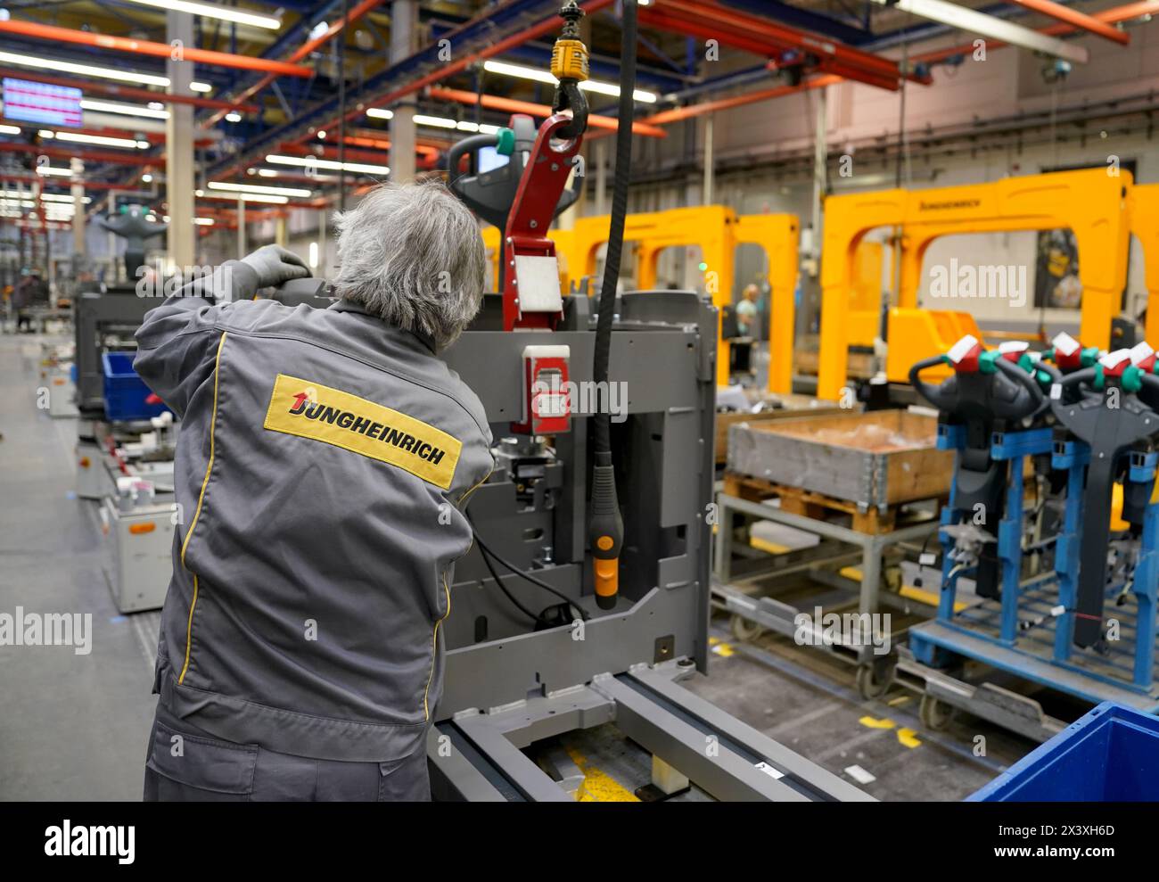 Norderstedt, Deutschland. April 2024. Ein Mitarbeiter arbeitet an der Montagelinie für Flurförderzeuge im Werk Jungheinrich AG. Jungheinrich ist ein Hersteller von Gabelstaplern und Palettenhubwagen. Quelle: Marcus Brandt/dpa/Alamy Live News Stockfoto