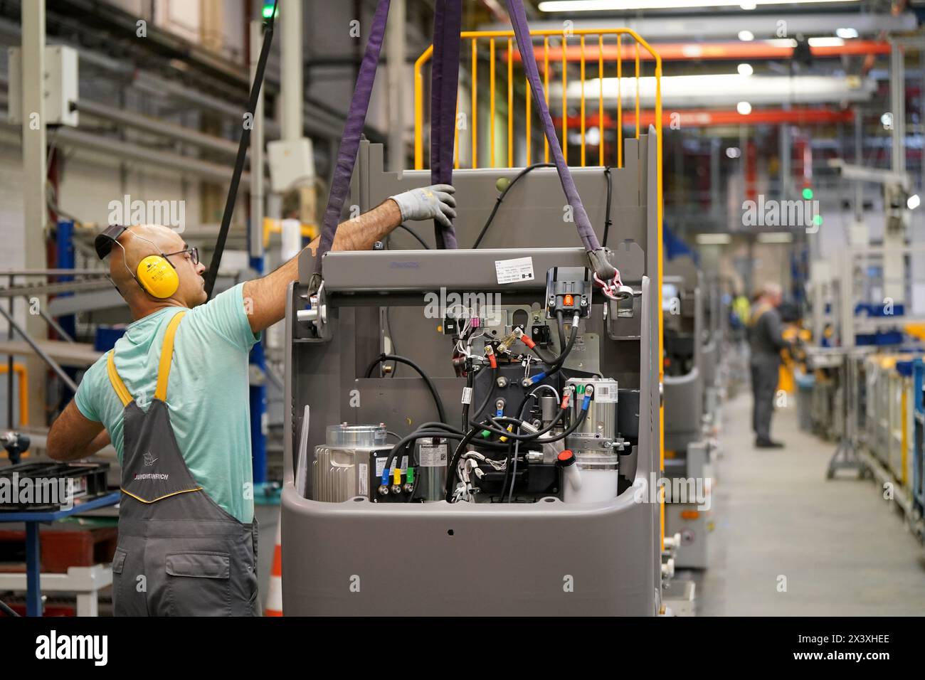 Norderstedt, Deutschland. April 2024. Ein Mitarbeiter arbeitet an der Montagelinie für Flurförderzeuge im Werk Jungheinrich AG. Jungheinrich ist ein Hersteller von Gabelstaplern und Palettenhubwagen. Quelle: Marcus Brandt/dpa/Alamy Live News Stockfoto
