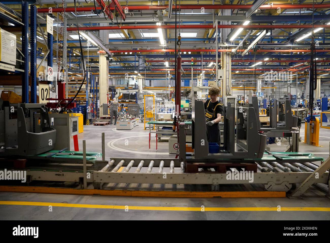 Norderstedt, Deutschland. April 2024. Mitarbeiter arbeiten an der Montagelinie für Flurförderzeuge im Werk Jungheinrich AG. Jungheinrich ist ein Hersteller von Gabelstaplern und Palettenhubwagen. Quelle: Marcus Brandt/dpa/Alamy Live News Stockfoto