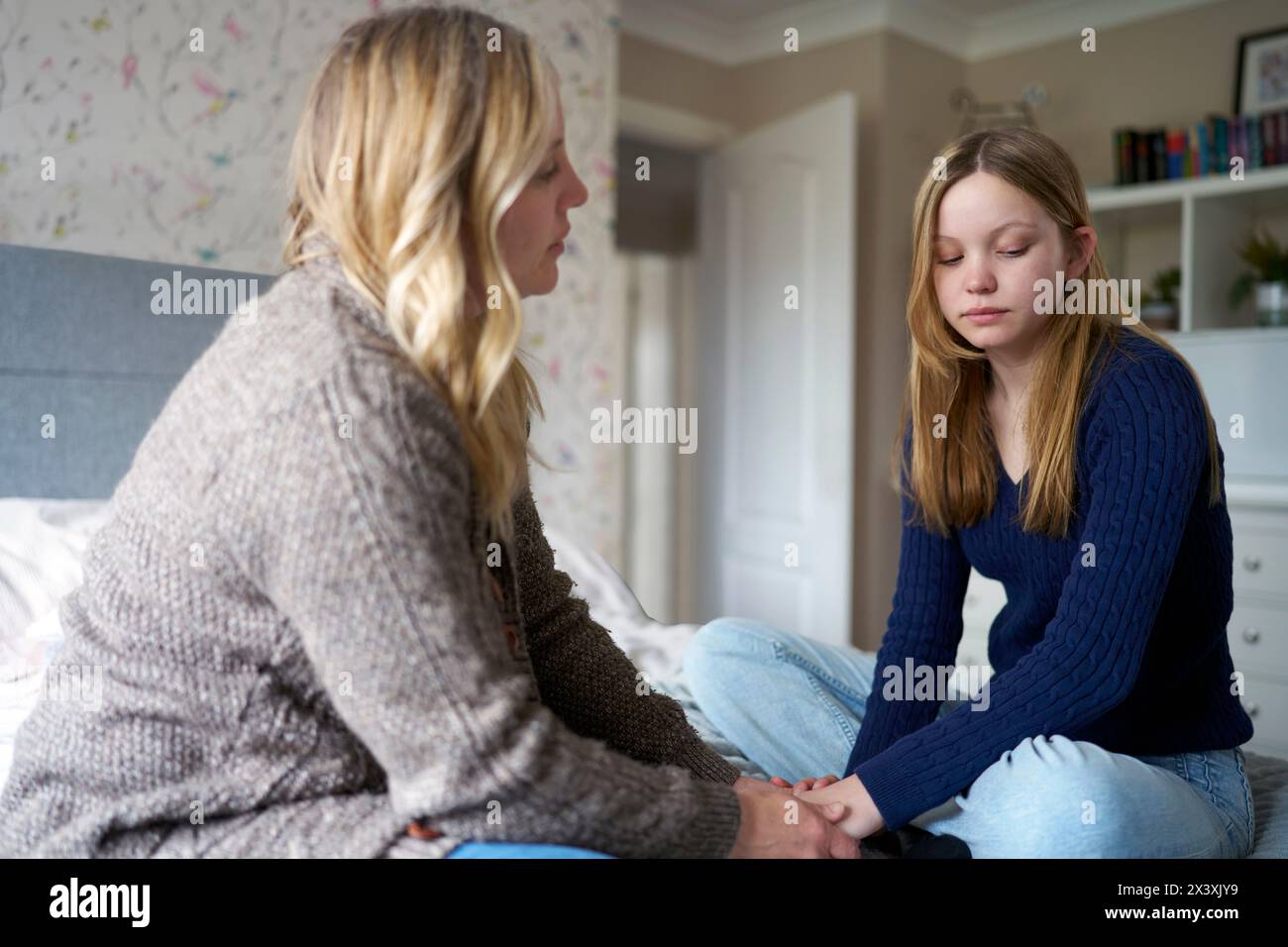 Reife Mutter Sitzt Auf Dem Bett Mit Unglücklicher Tochter Im Teenageralter Zu Hause Und Diskutiert Das Problem Stockfoto