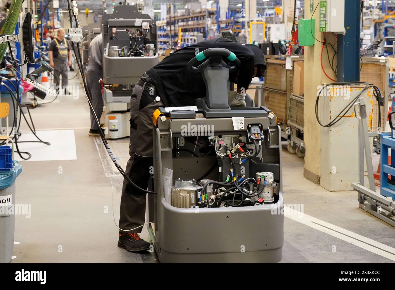 Norderstedt, Deutschland. April 2024. Mitarbeiter arbeiten an der Montagelinie für Flurförderzeuge im Werk Jungheinrich AG. Jungheinrich ist ein Hersteller von Gabelstaplern und Palettenhubwagen. Quelle: Marcus Brandt/dpa/Alamy Live News Stockfoto