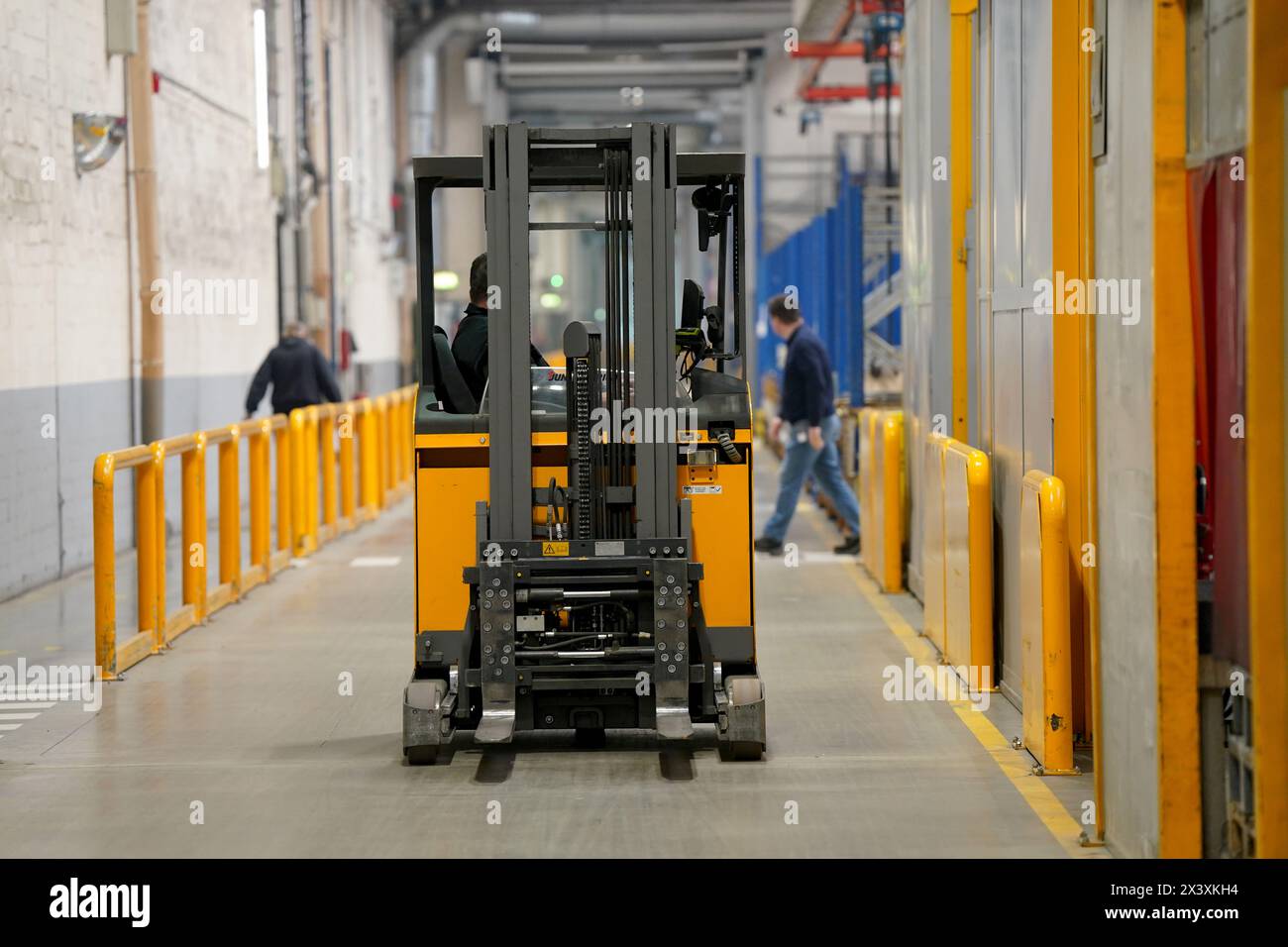 Norderstedt, Deutschland. April 2024. Ein Gabelstapler fährt durch die Werkshalle der Jungheinrich AG. Jungheinrich ist ein Hersteller von Gabelstaplern und Palettenhubwagen. Quelle: Marcus Brandt/dpa/Alamy Live News Stockfoto