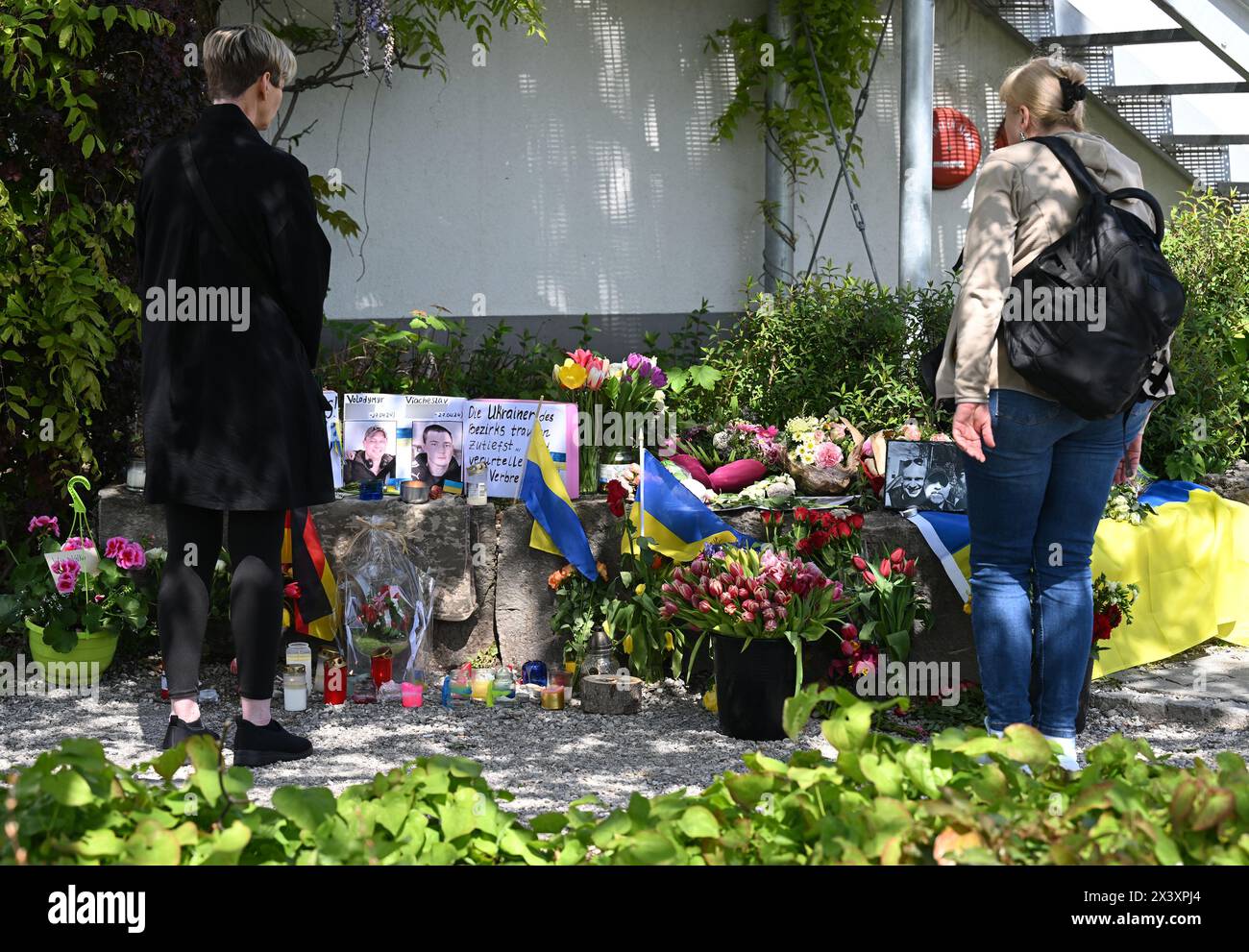 29. April 2024, Murnau am Staffelsee: Neben dem Einkaufszentrum, wo am Samstagabend zwei Männer aus der Ukraine getötet wurden, haben Menschen Blumen und Plakate gelegt. Die beiden getöteten Ukrainer waren Mitglieder der Armee. Foto: Angelika Warmuth/dpa - ACHTUNG: Namen wurden aus rechtlichen Gründen pixeliert Stockfoto