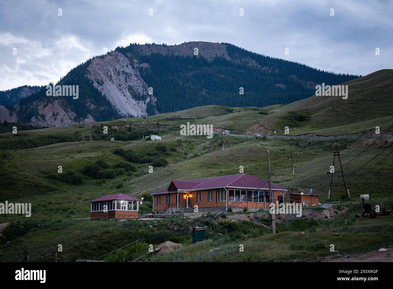 Ein Jurtencamp in den kirgisischen Bergen mit einem wunderschönen Blick auf den Sonnenuntergang. Traditionelle Filzjurten, die von Nomaden im Sommer verwendet werden. Stockfoto