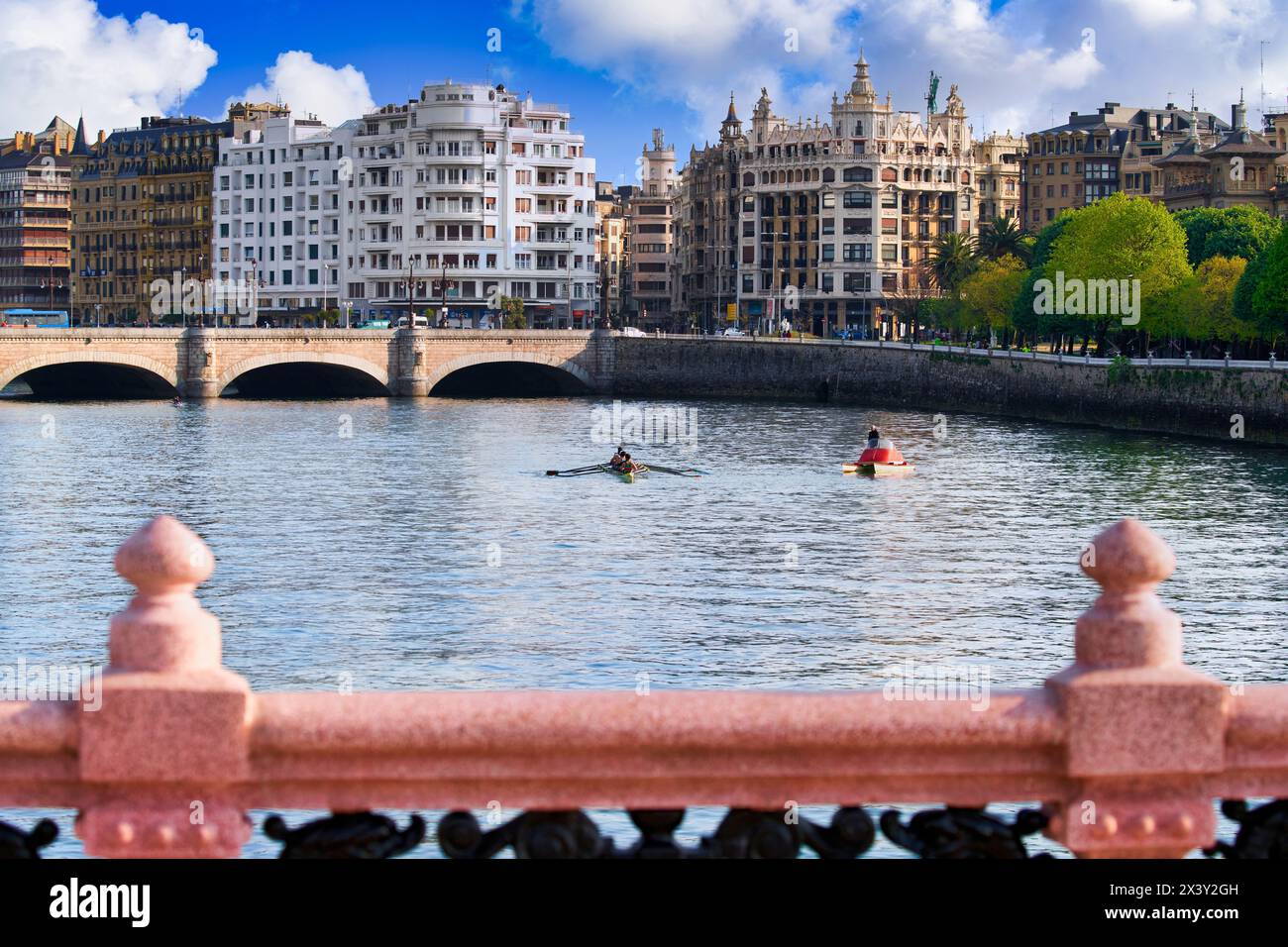 Ruderer, die auf dem Urumea River trainieren, Maria Cristina und Santa Catalina Bridge, Maria Cristina Bridge elegante Struktur über den Fluss Urum Stockfoto