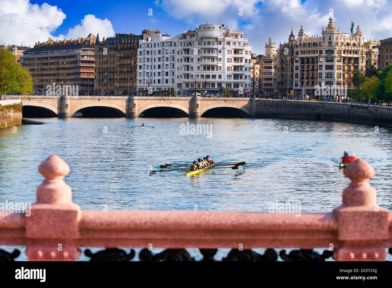 Ruderer, die auf dem Urumea River trainieren, Maria Cristina und Santa Catalina Bridge, Maria Cristina Bridge elegante Struktur über den Fluss Urum Stockfoto