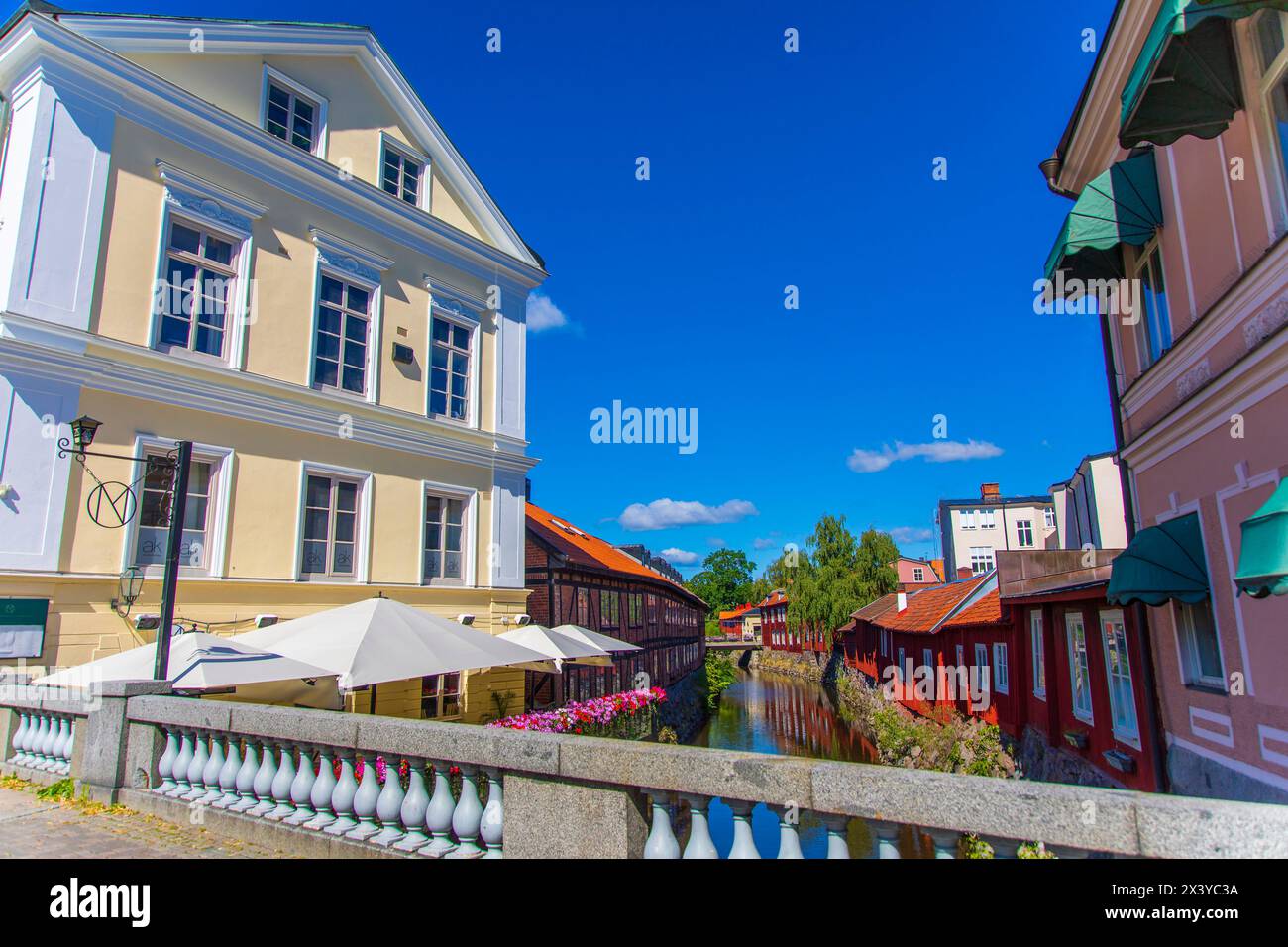 Europa, Skandinavien, Schweden.. Vaestmanland. Vaesteras. Rote Holzhäuser am Ufer des Flusses Svartan Stockfoto