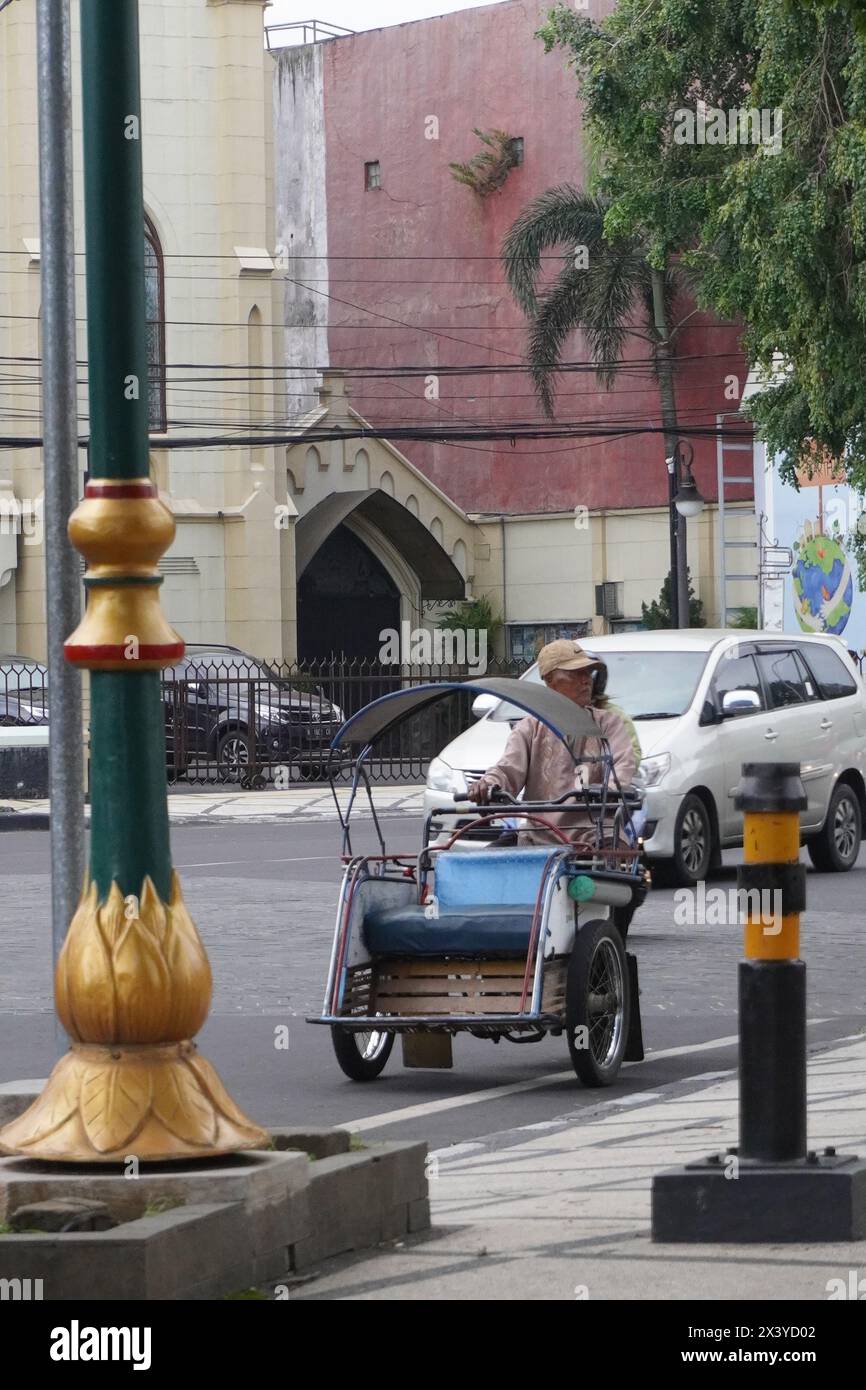Ein indonesischer Pedikabfahrer fährt auf der Hauptstraße Stockfoto
