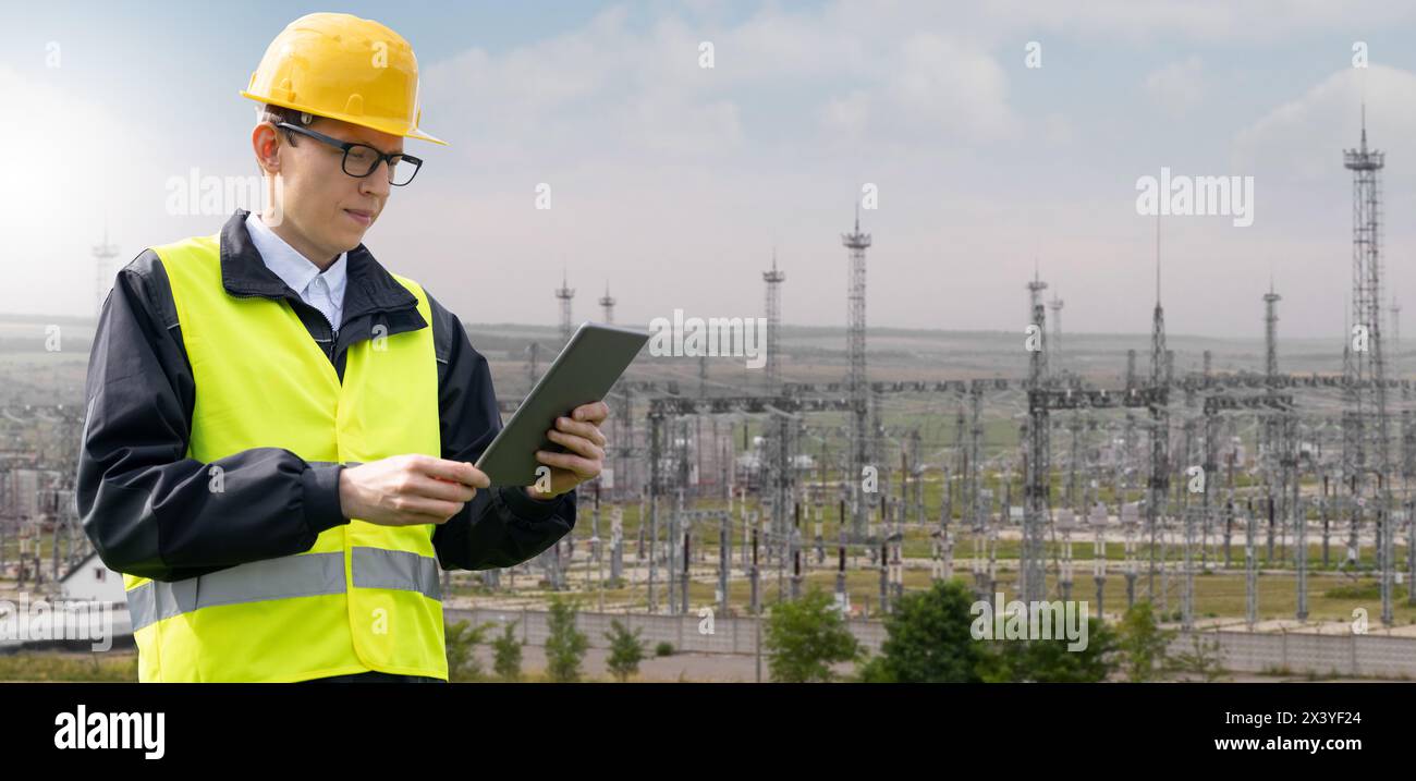 Mitarbeiter mit einem digitalen Tablet auf einem Hintergrund eines Kraftwerks. Stockfoto
