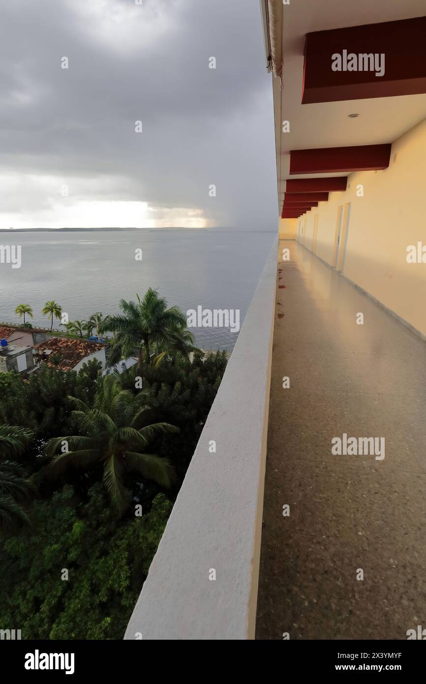 204 der offene Flur, der zu den Zimmern im Jagua Hotel führt, bietet einen Blick auf den stürmischen Himmel über der Jagua Bay nach starkem tropischem Regen. Cienfuegos-Kuba. Stockfoto