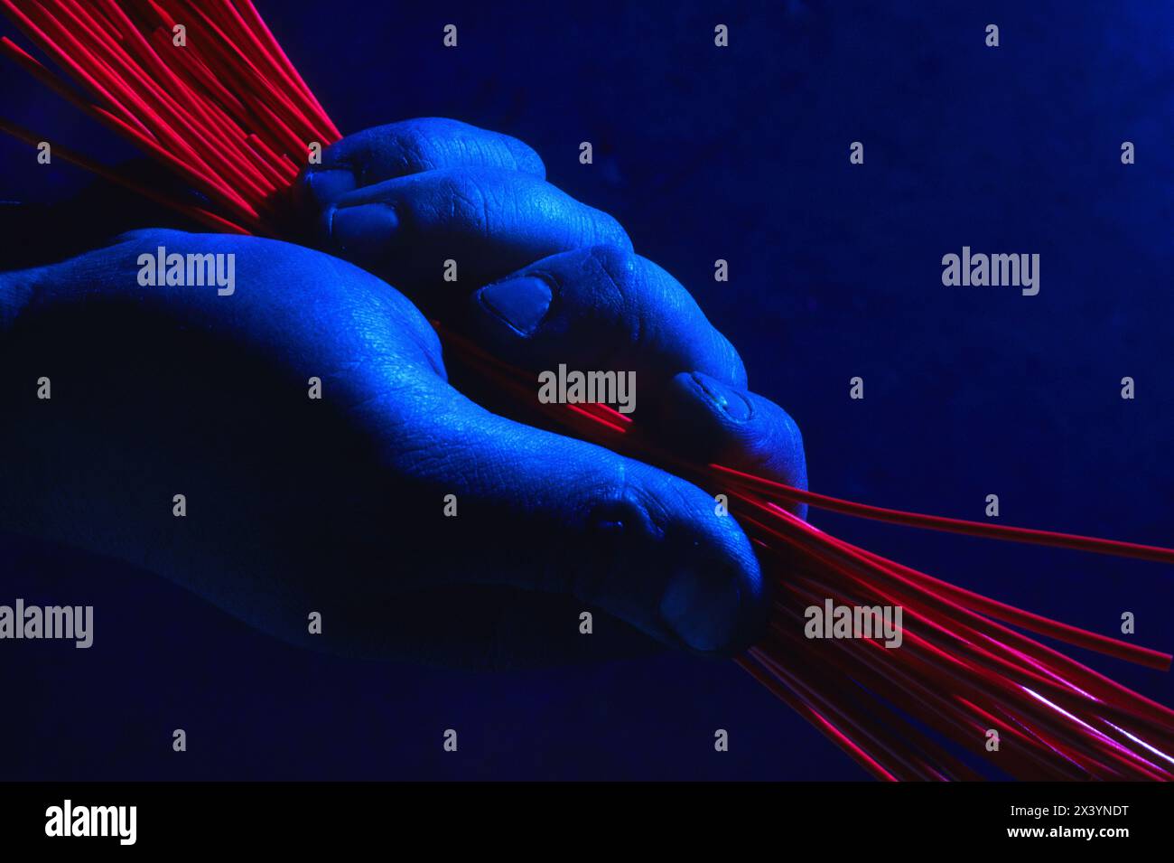 Rote Kunststoffdrähte in blauer Hand Stockfoto