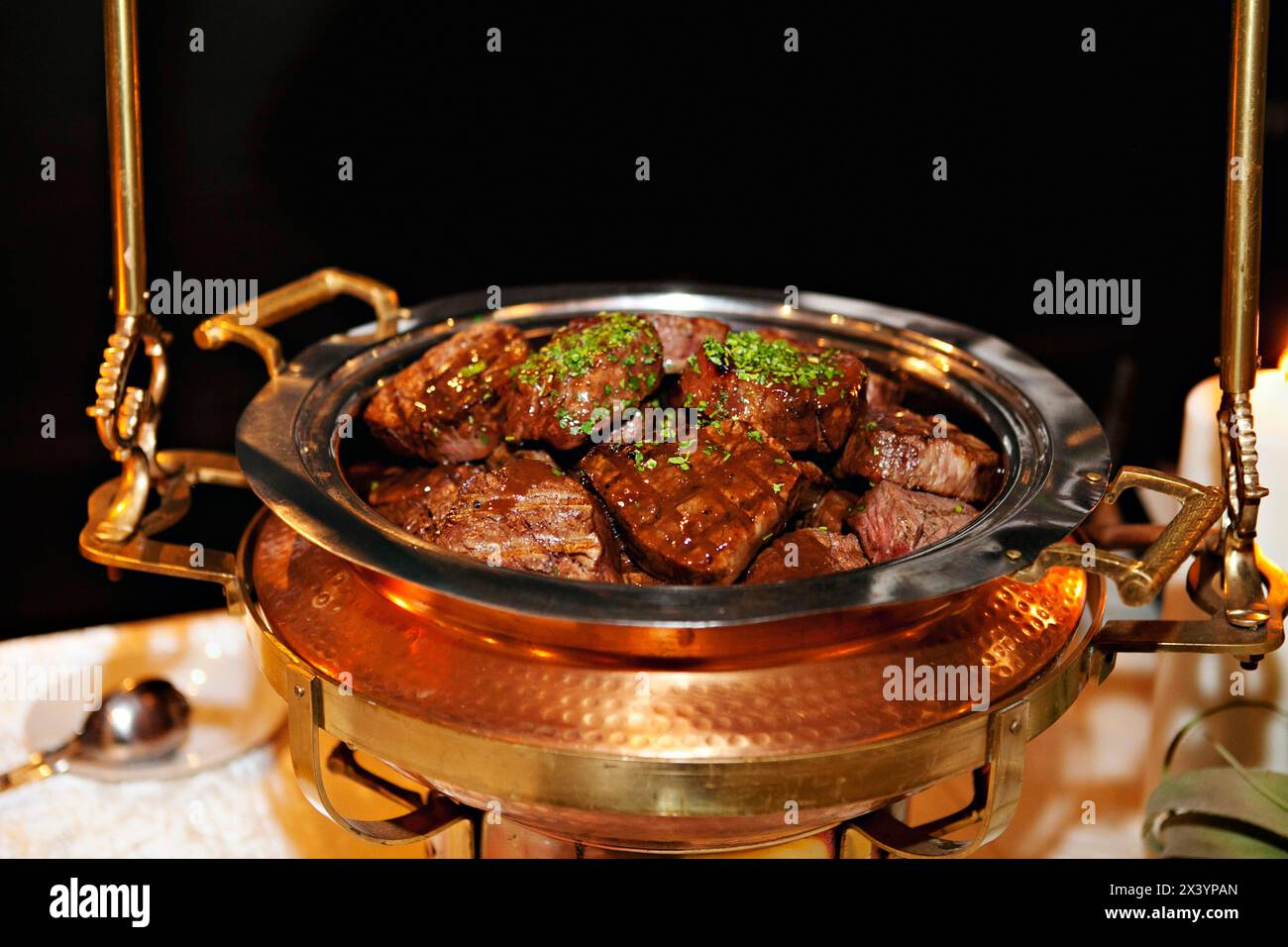 Gegrillte Steaks, heiß in einer Kupferscheuerschale serviert. Stockfoto