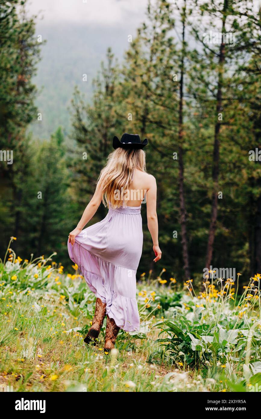 Teenager-Mädchen, das in westlicher Boho-Mode im Wald läuft Stockfoto