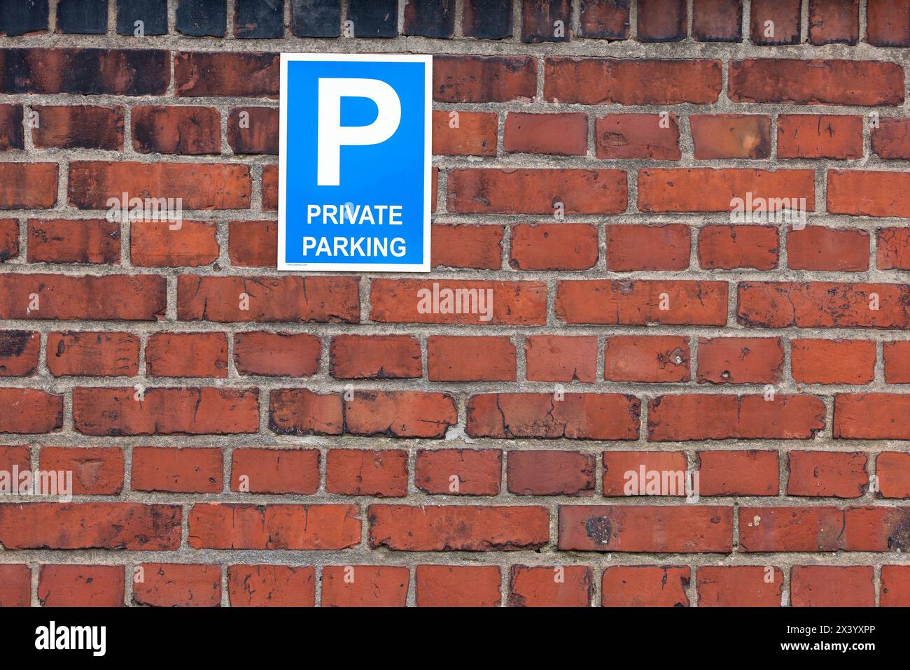 Privates Parkschild an roter Backsteinmauer Stockfoto