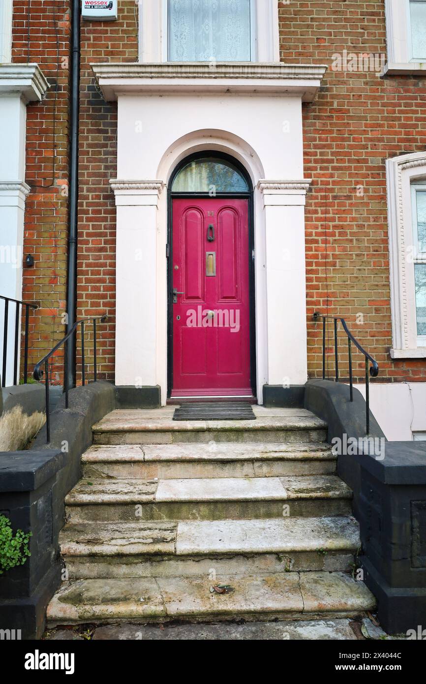 Bristol, England, 29. März 2024: Typisch britisches Haus mit farbenfroher pinkfarbener Tür in Bristol, England Stockfoto