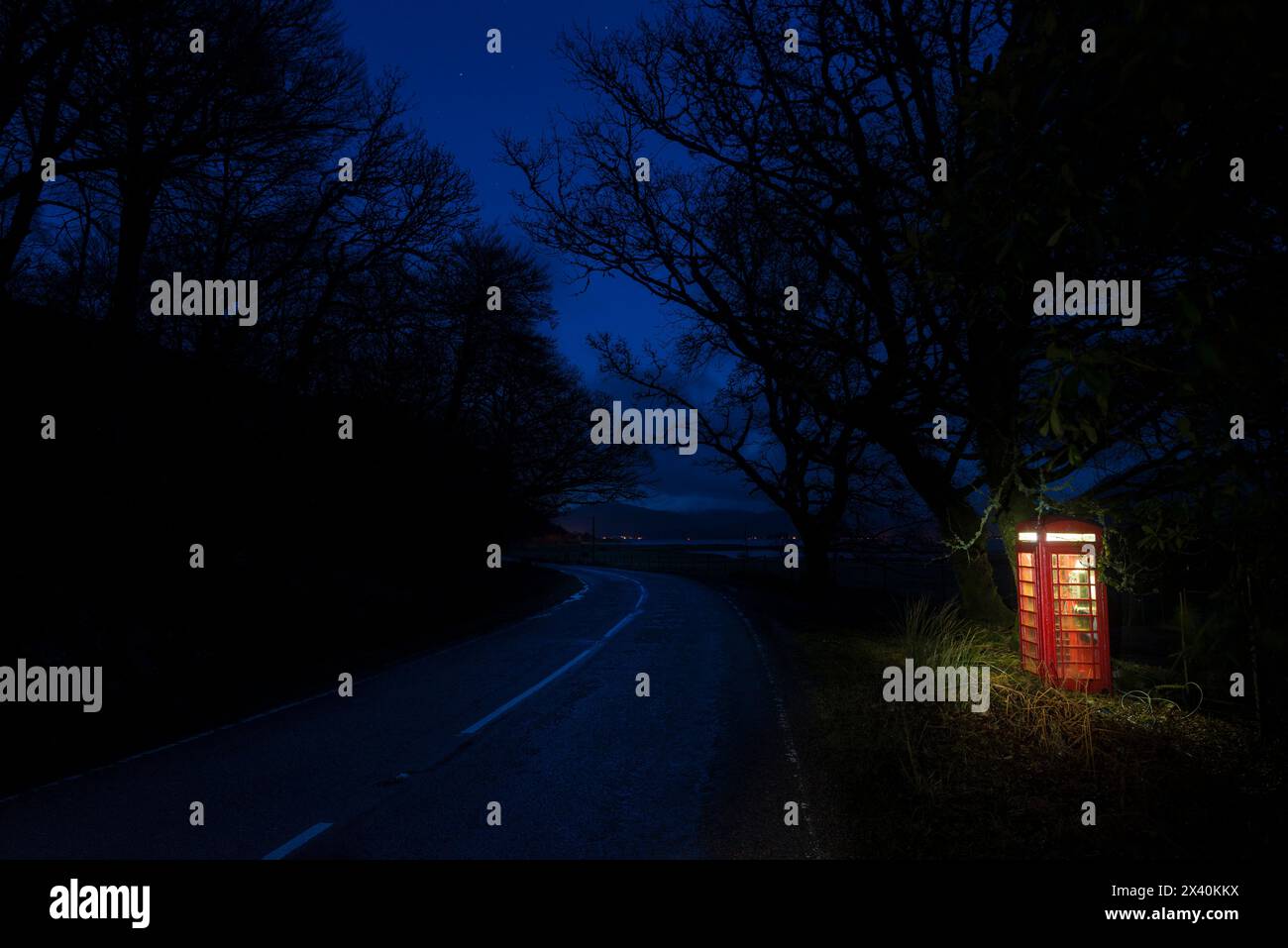 Nachts beleuchtete Telefonbox auf einer ruhigen Straße in der Nähe von Corran auf der Ardnamurchan-Halbinsel; Schottland Stockfoto