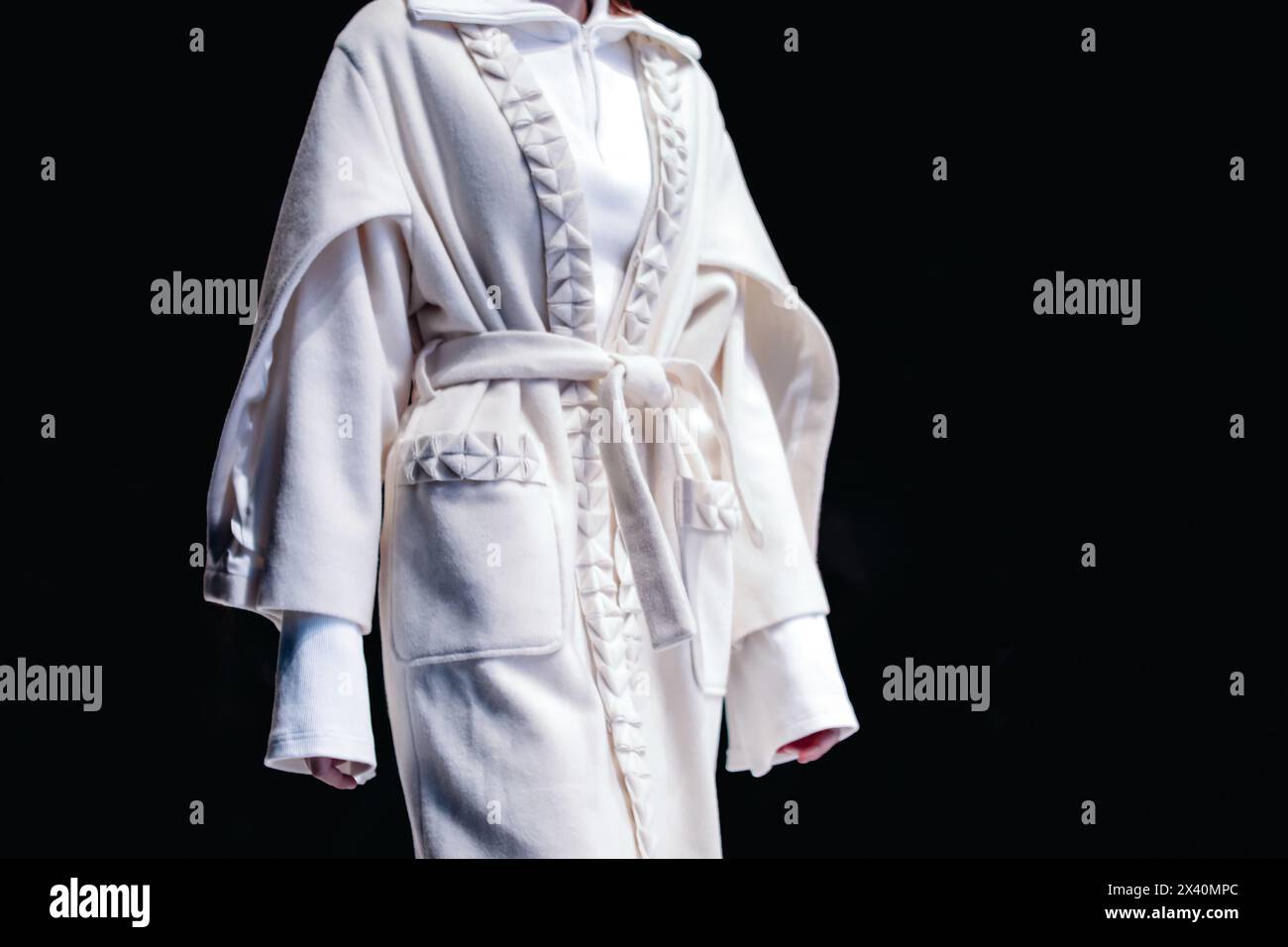 Modische Details des weißen, langen, gepolsterten Strickjacke mit Gürtel, kreative Freizeitkleidung Stockfoto