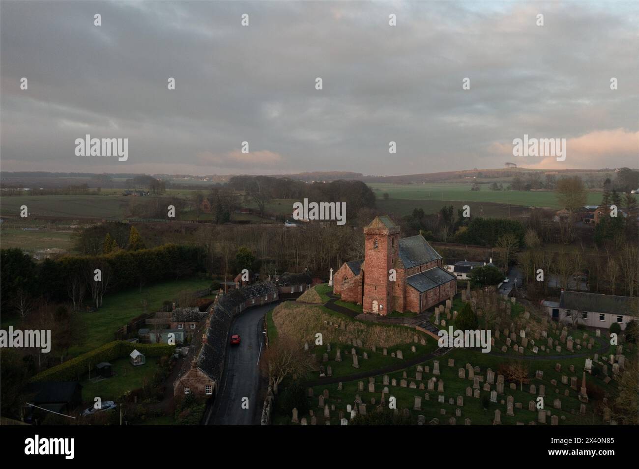 St. Vigeans Church aus der Vogelperspektive bei Sonnenuntergang, historische Pfarrei aus rotem Sandstein, umgeben von Friedhof und Landschaft, Angus, Schottland. Stockfoto