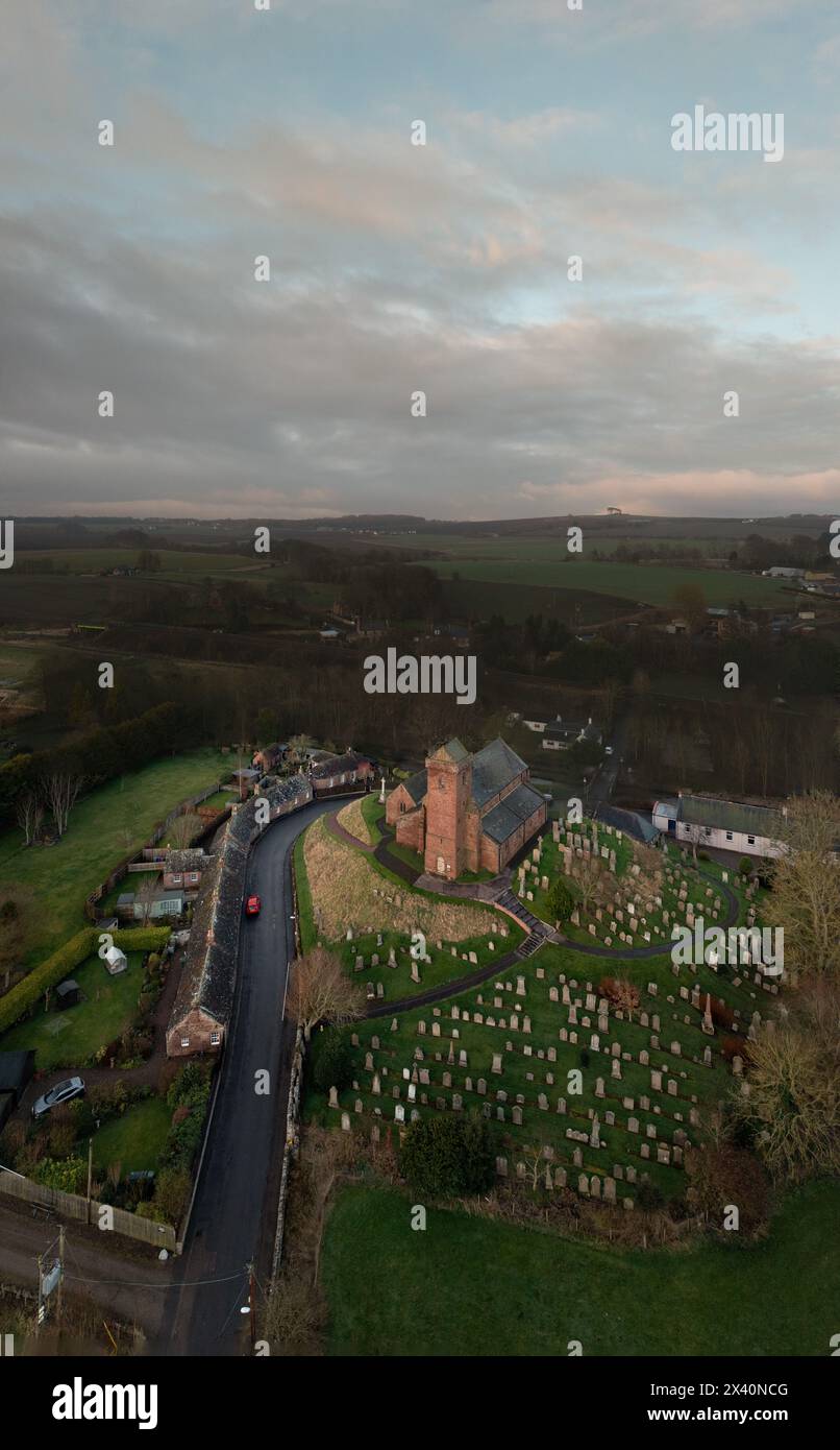 St. Vigeans Church aus der Vogelperspektive bei Sonnenuntergang, historische Pfarrei aus rotem Sandstein, umgeben von Friedhof und Landschaft, Angus, Schottland. Stockfoto