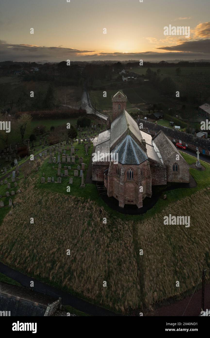 St. Vigeans Church aus der Vogelperspektive bei Sonnenuntergang, historische Pfarrei aus rotem Sandstein, umgeben von Friedhof und Landschaft, Angus, Schottland. Stockfoto