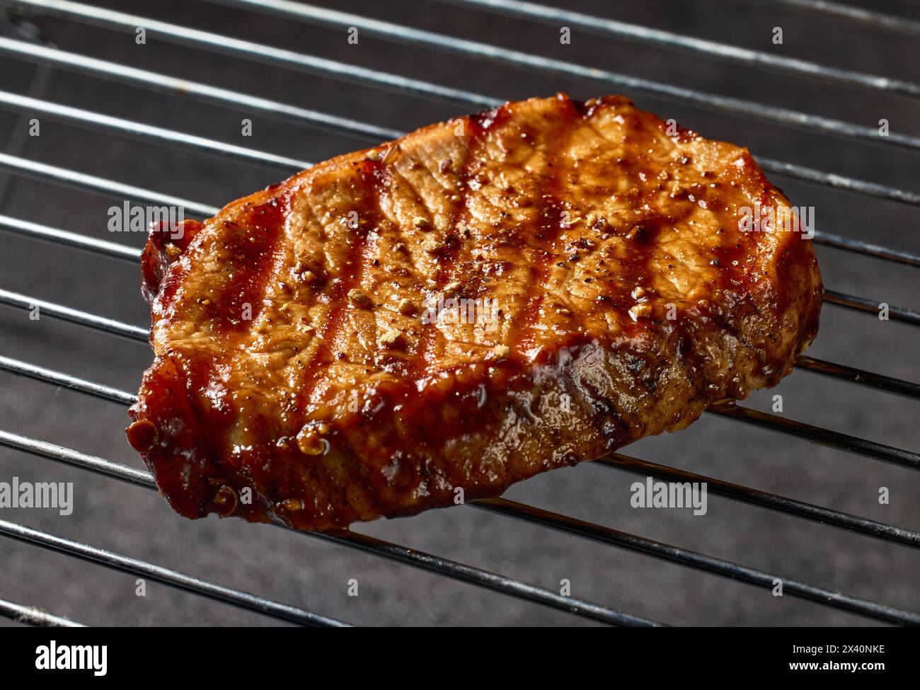 Frisch gegrilltes saftiges Steak in Nahaufnahme auf schwarzem Hintergrund Stockfoto