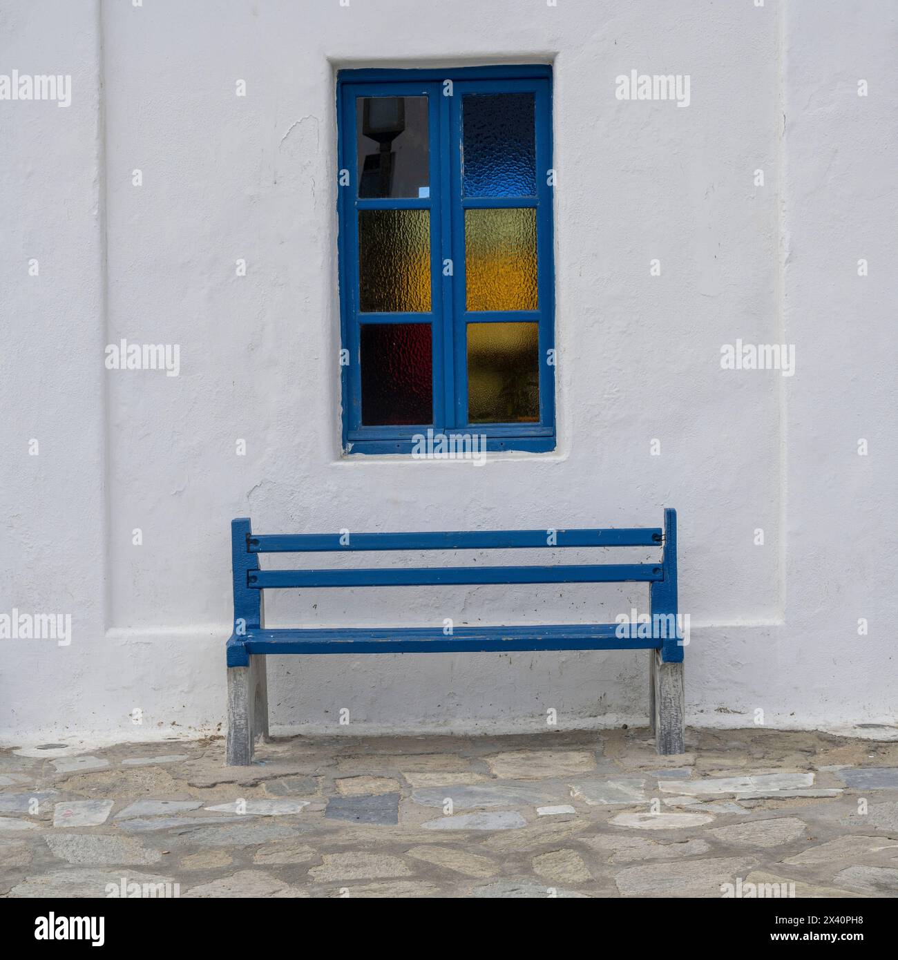 Blaue Bank und Fensterrahmen vor einer weiß getünchten Wand; Mykonos, Südägäis, Griechenland Stockfoto