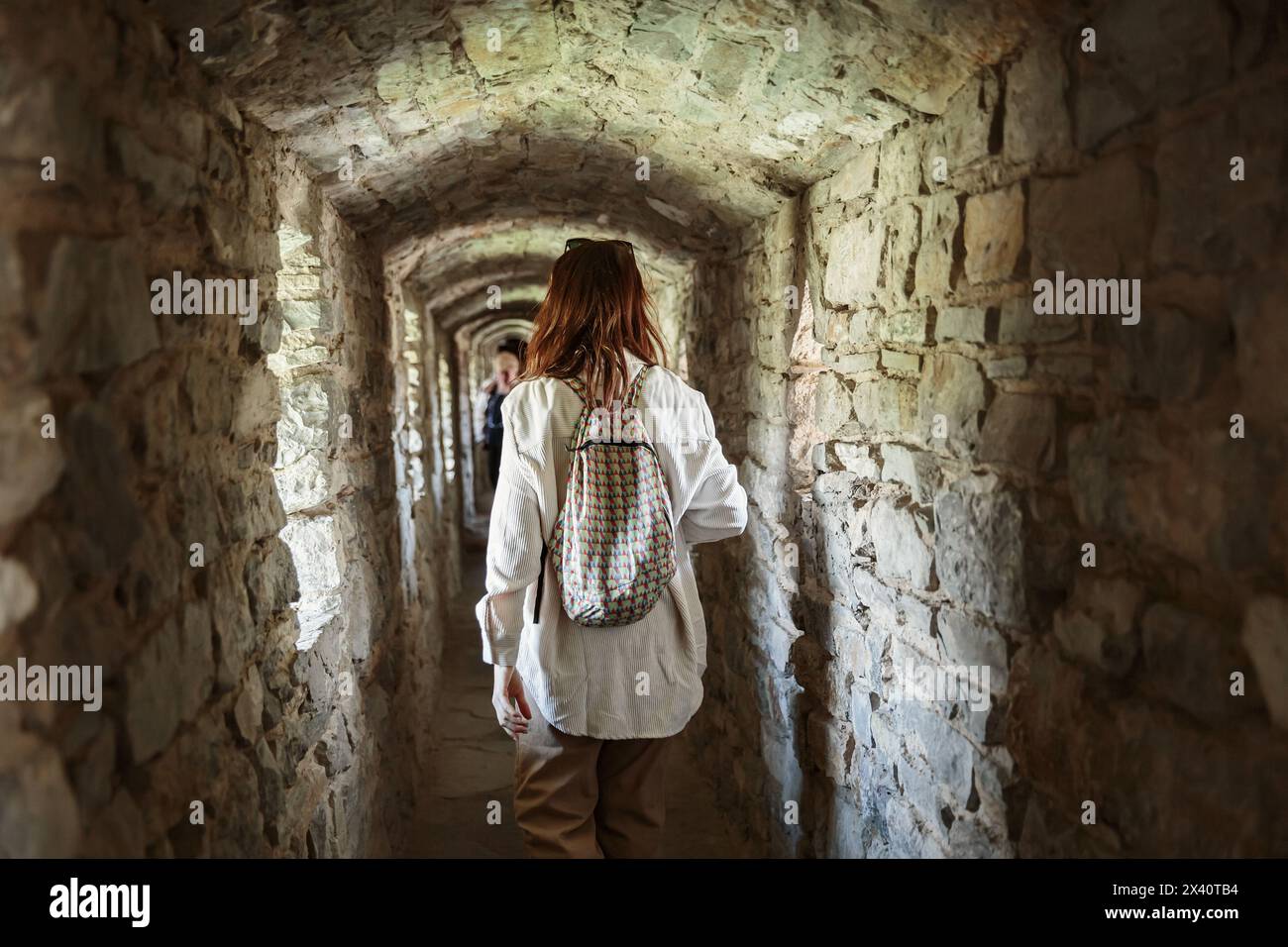 Frau macht Fotos, während sie im Korridor des alten Schlosses steht Stockfoto