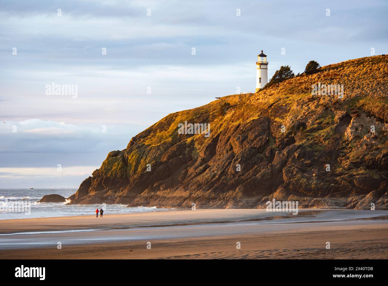 Ein paar spazieren am Strand unterhalb des North Head Lighthouse im Cape Desappointment State Park in der Nähe der Mündung des Columbia River im Bundesstaat Washington Stockfoto