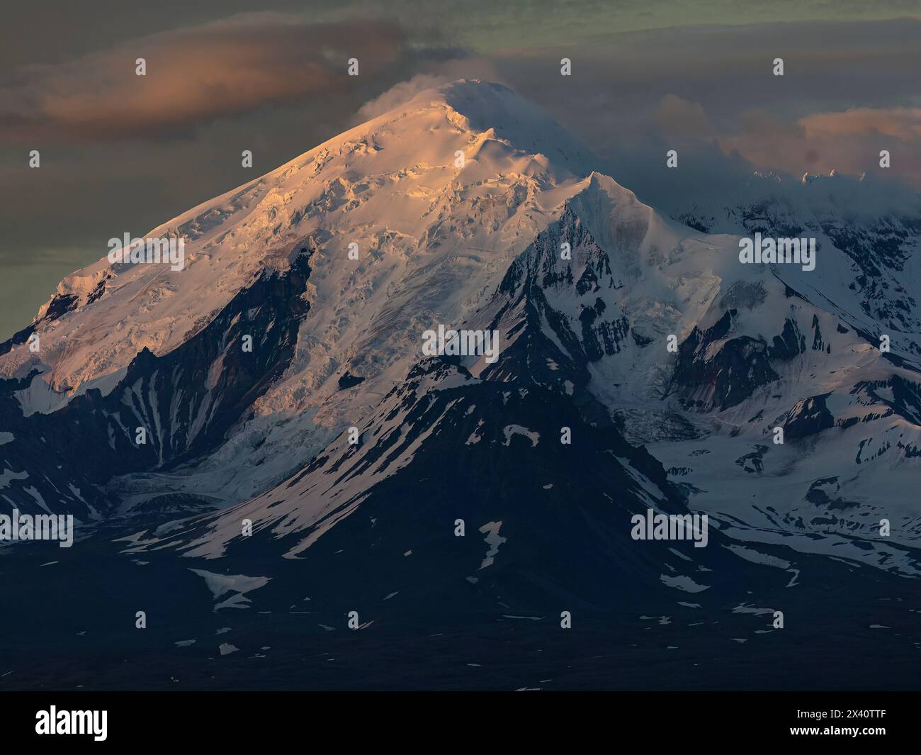 Nahaufnahme des schneebedeckten Mount Drum mit dem alpenglow und Schatten, die seinen Gipfel in Alaskas Wrangell Mountains betonen, spät am Abend in Ohr... Stockfoto