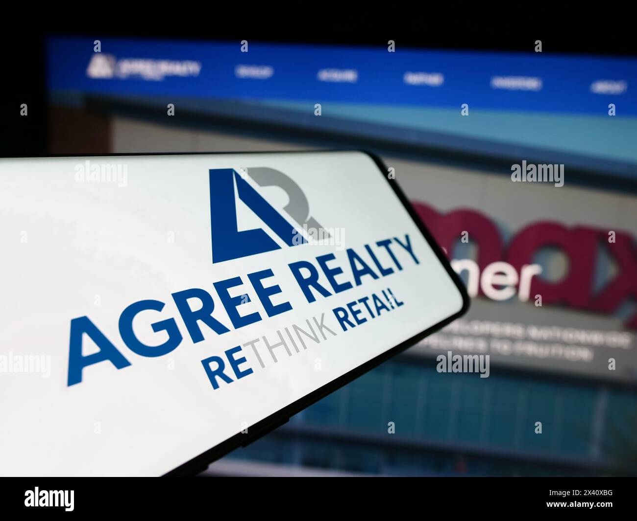 Mobiltelefon mit Logo der amerikanischen Immobiliengesellschaft Agree Realty Corporation vor der Website. Fokussieren Sie sich auf die linke Mitte des Telefondisplays. Stockfoto