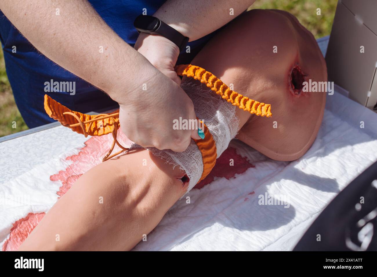 Der Sanitäter legt einen Tourniquet am Arm an. Medizinische Ausbildung. Stockfoto