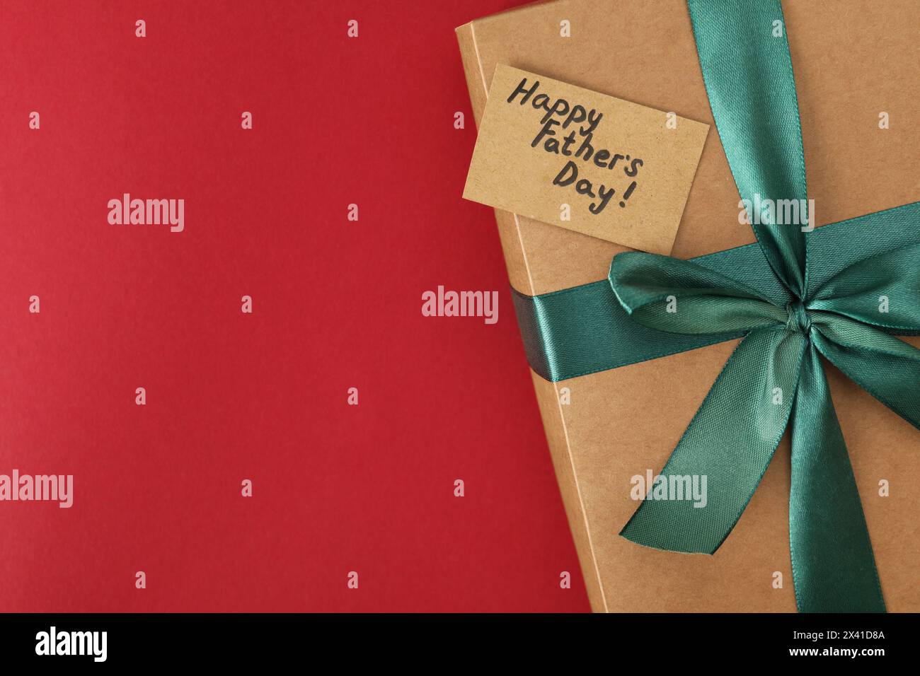 Alles Gute zum Vatertag. Geschenkbox und Karte mit Grüßen auf rotem Hintergrund, Draufsicht. Leerzeichen für Text Stockfoto