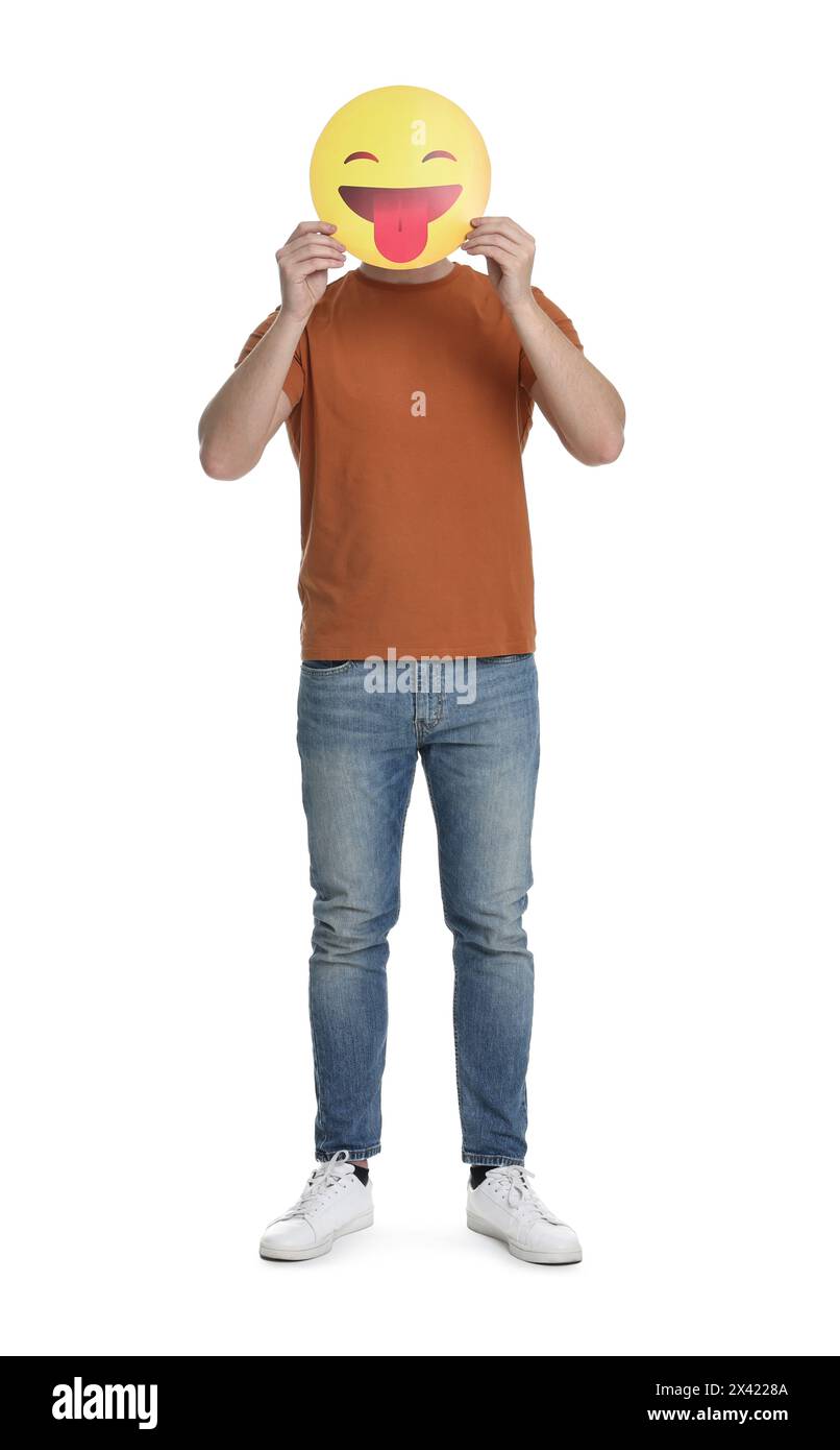 Mann, der das Gesicht mit Emoticon bedeckt, der die Zunge auf weißem Hintergrund hinausragt Stockfoto