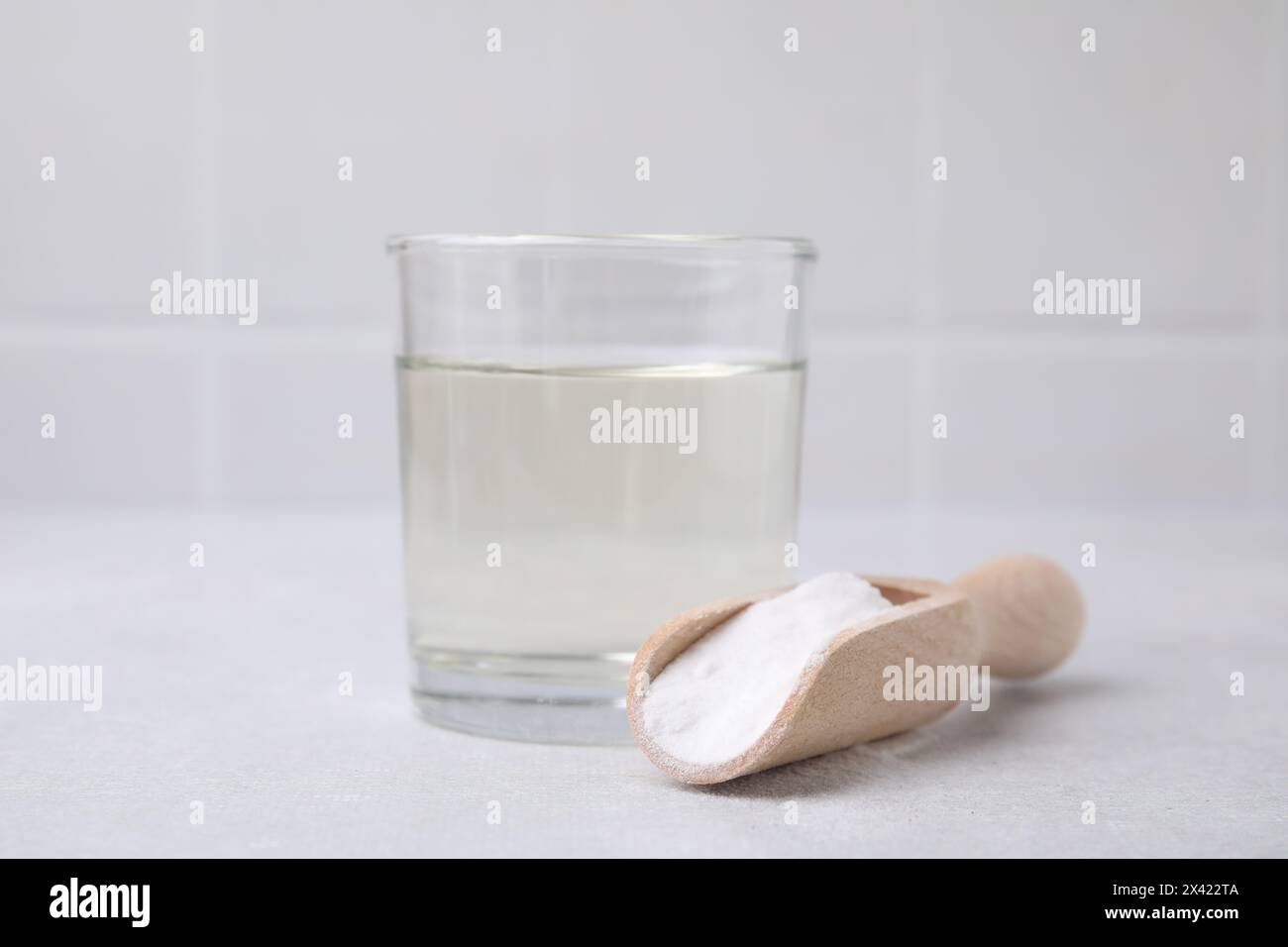Essig in Glas, Natron und Holzlöffel auf dem Leuchttisch Stockfoto