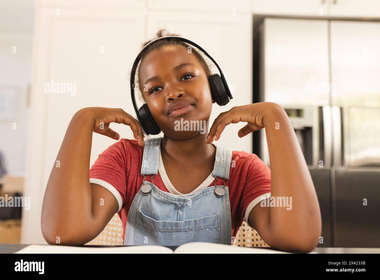 Afroamerikanisches Mädchen, das Kopfhörer trägt und zu Hause Musik genießt Stockfoto