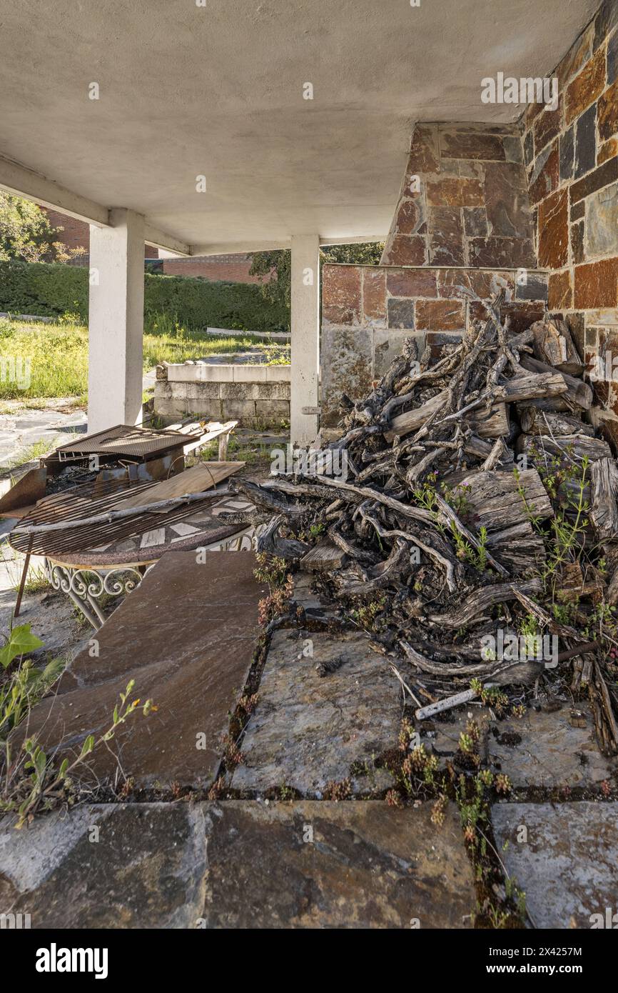 Ein Grillofen mit Grill und eigenem Dach und viel trockenem Holz Stockfoto