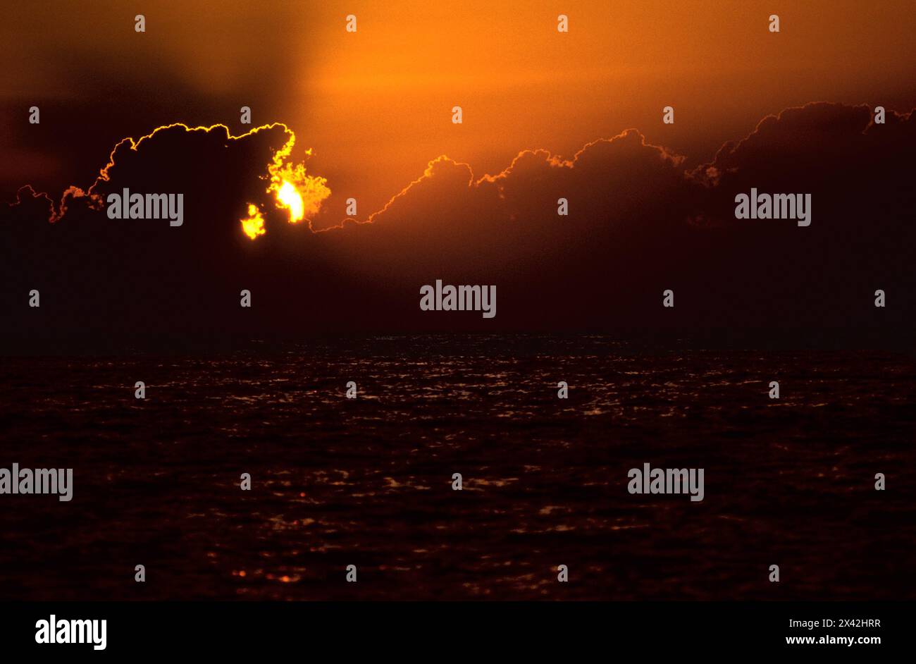 Aufgehende Sonne hinter dunklen Wolken über dem Mittelmeer Stockfoto