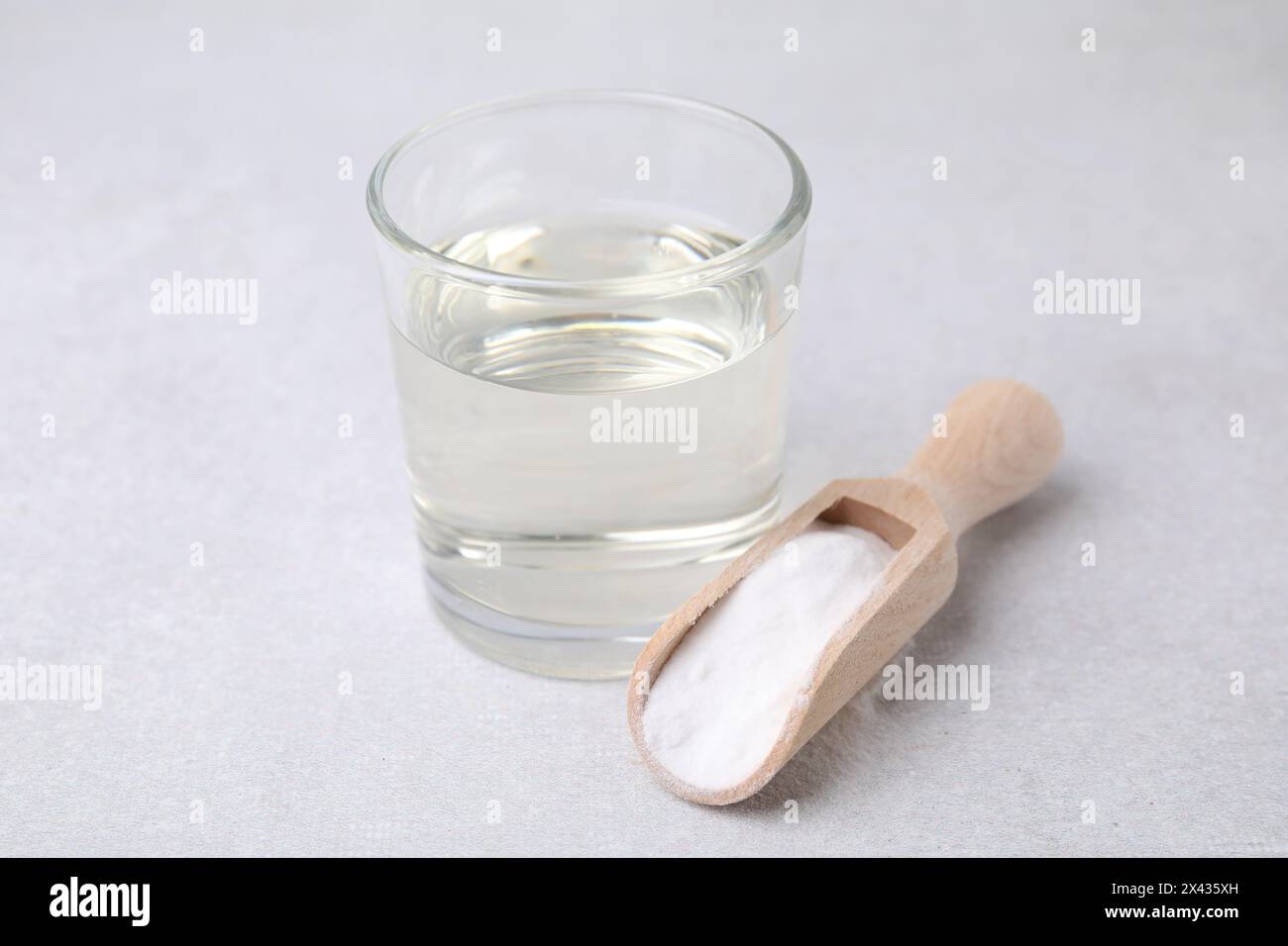 Essig in Glas, Natron und Holzlöffel auf dem Leuchttisch Stockfoto