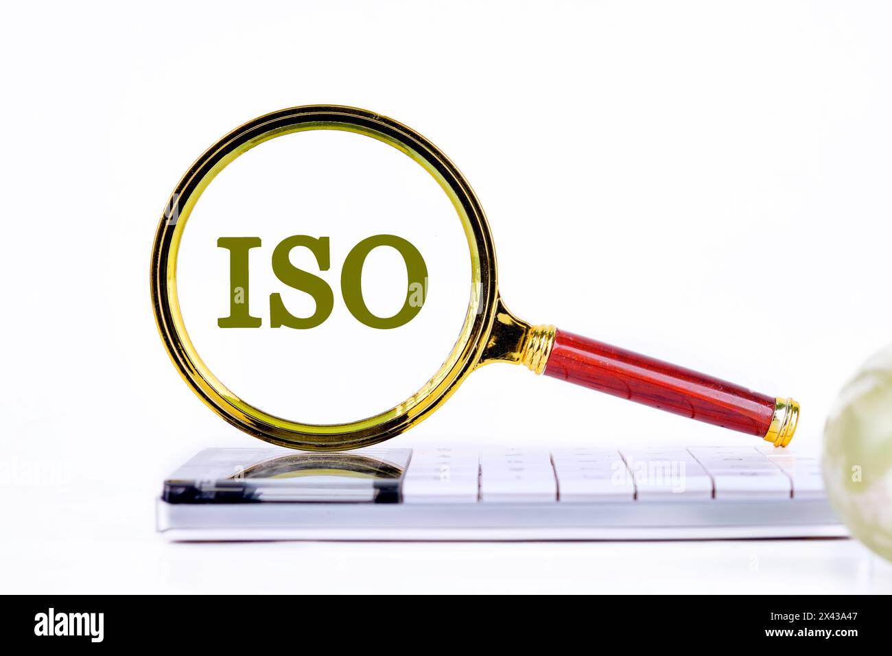 ISO. Internationale Organisation für Normung. Eine Word ISO-Inschrift wurde mit einer Lupe auf dem Rechner gefunden. Konzeptfoto Stockfoto