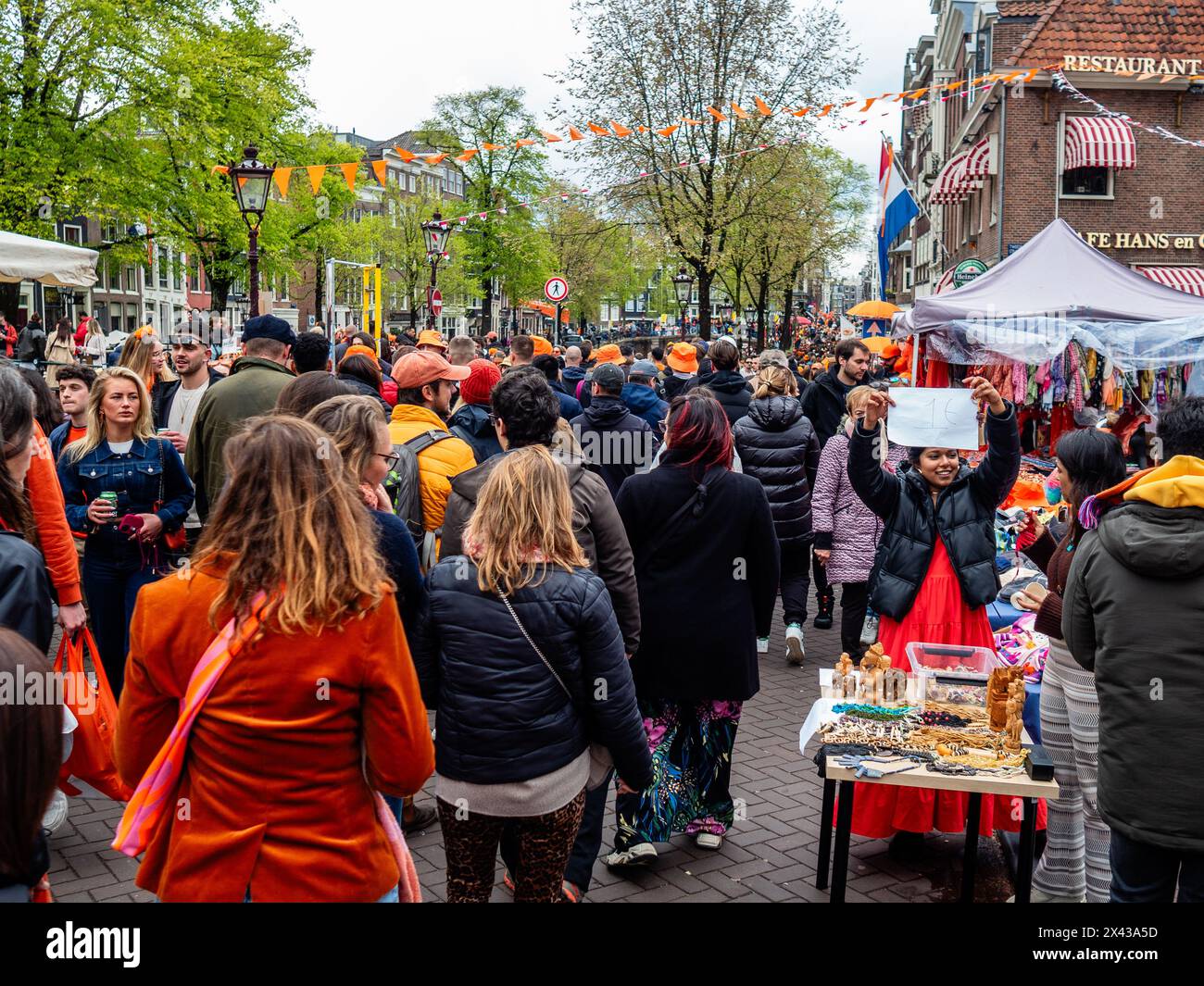 27. April, Amsterdam. Der Königstag ist bekannt für eines der größten und farbenprächtigsten Feste des Landes, insbesondere in Amsterdam. Die Stadt ist voller Orange, während die Menschen die größte Straßenparty des Jahres genießen, die freien Märkte genießen und Spaß auf den Booten entlang der Kanäle haben. Stockfoto
