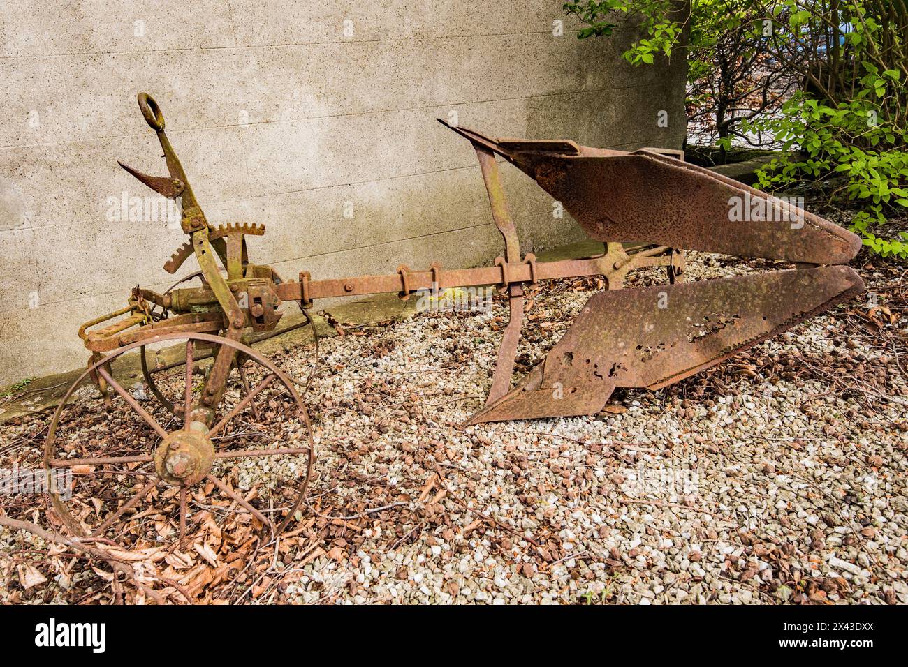 Ein alter rostiger Pflug, ein altes Landwirtschaftsgerät, in einem Garten in Giggleswick North Yorkshire Stockfoto